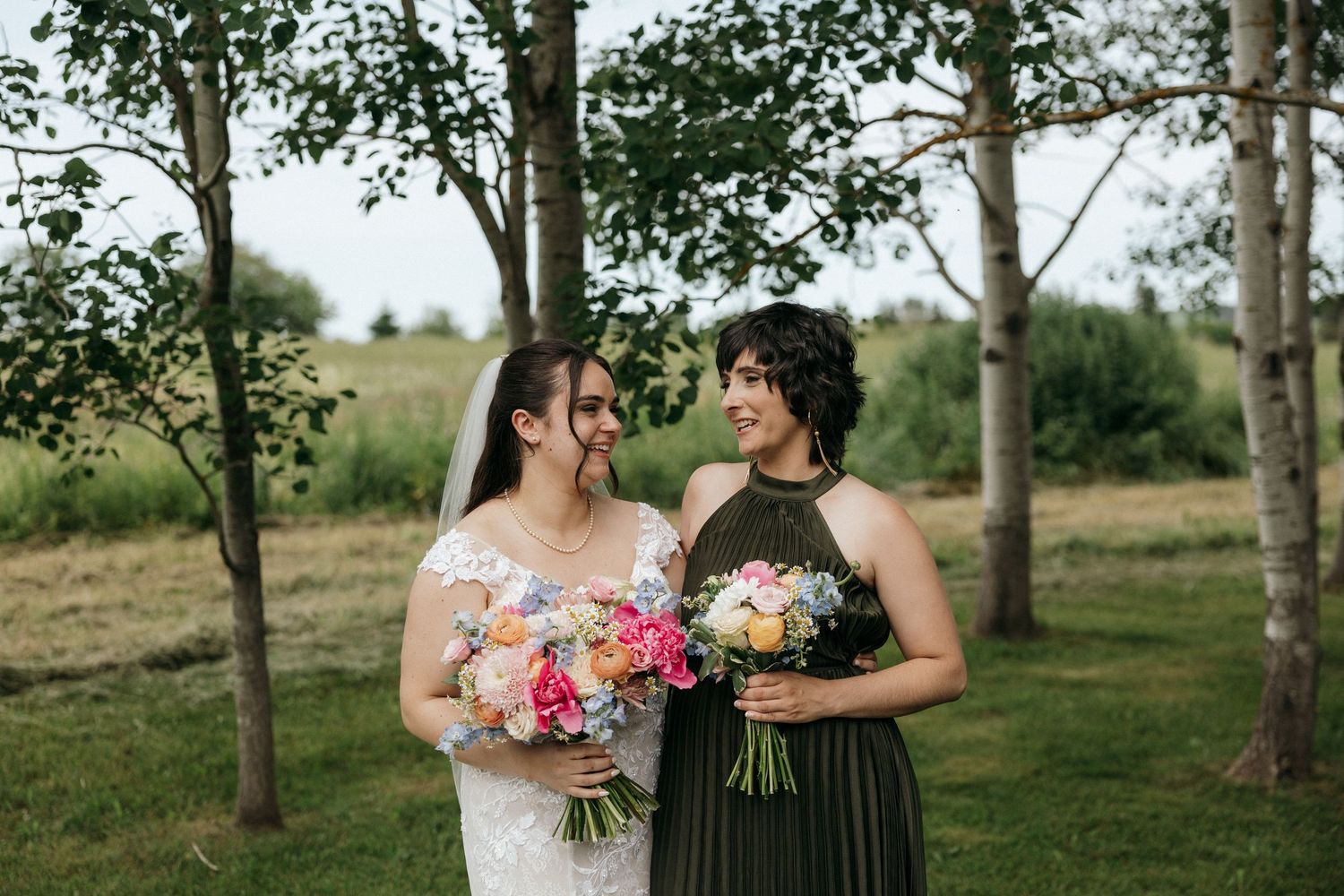 Candid wedding party moment captured in a birch tree grove.
