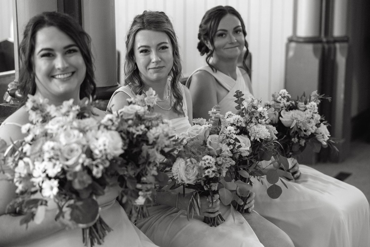 Row of elegant floral bouquets with pink and white flowers at a wedding.