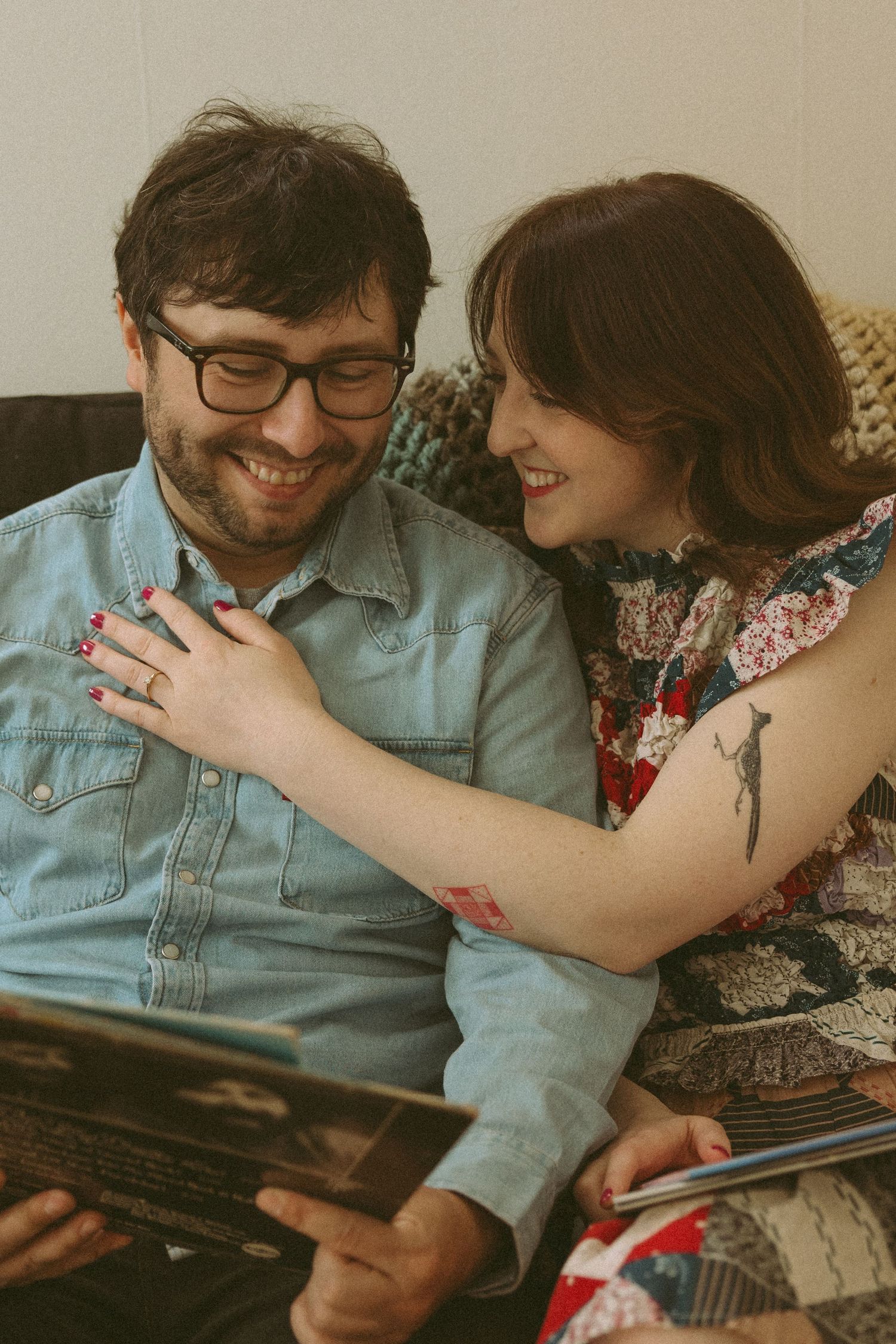 Vintage-toned photo of couple looking at books together on couch.