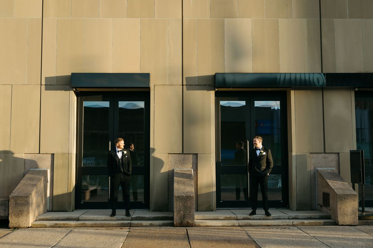 A series of architectural columns create shadows on a modern building exterior.
