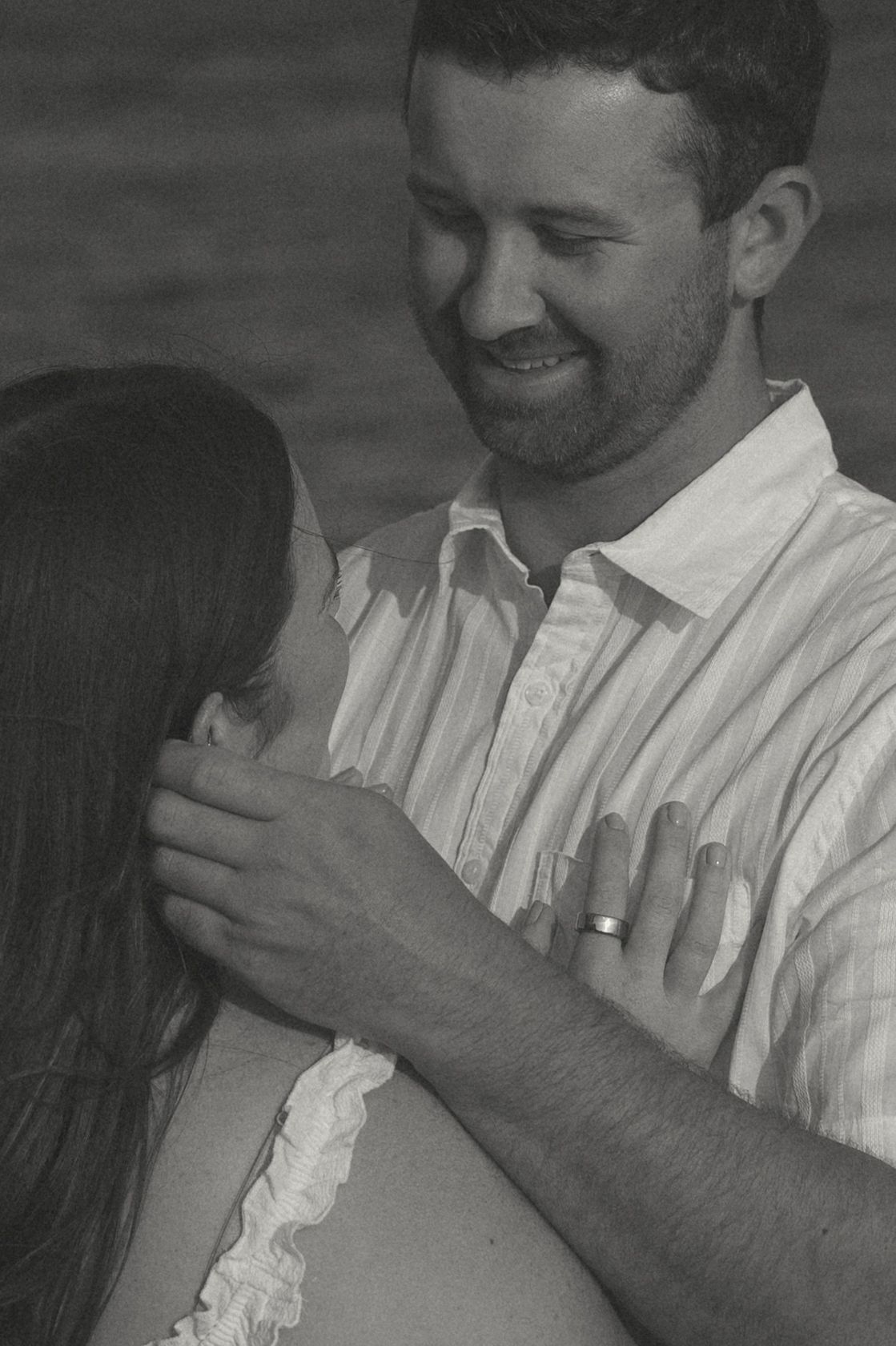An intimate black and white portrait of a couple sharing a tender moment.
