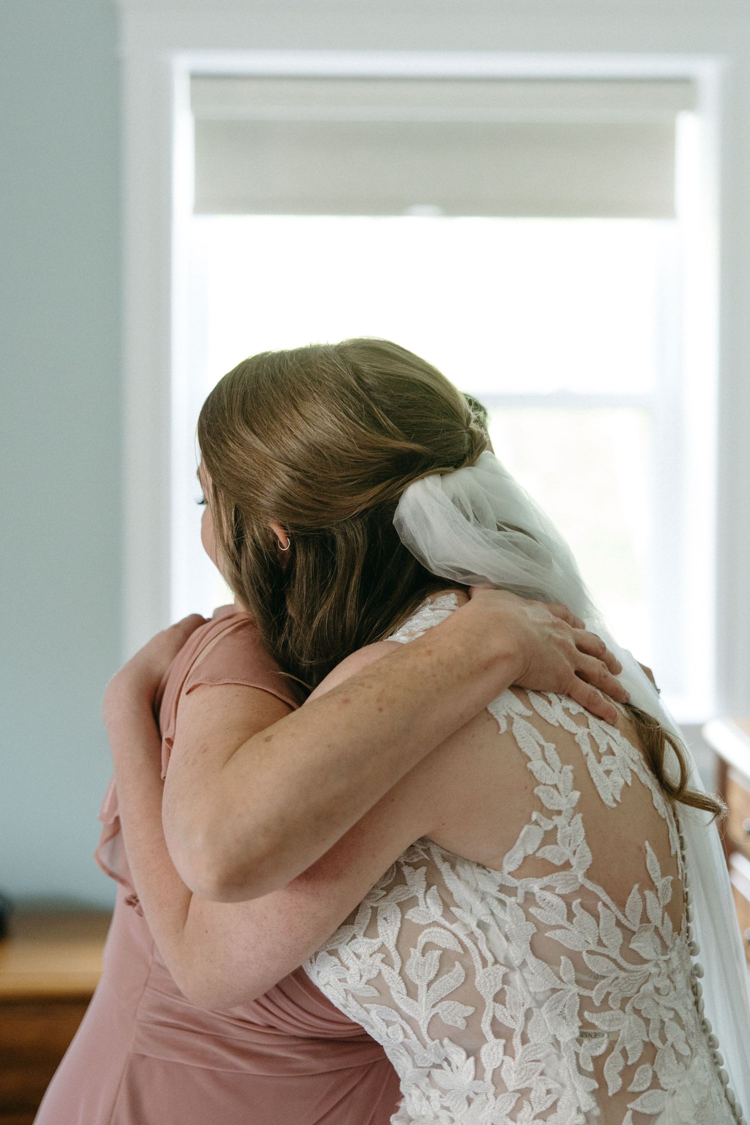 A touching moment between two people sharing an emotional hug in a bright room.
