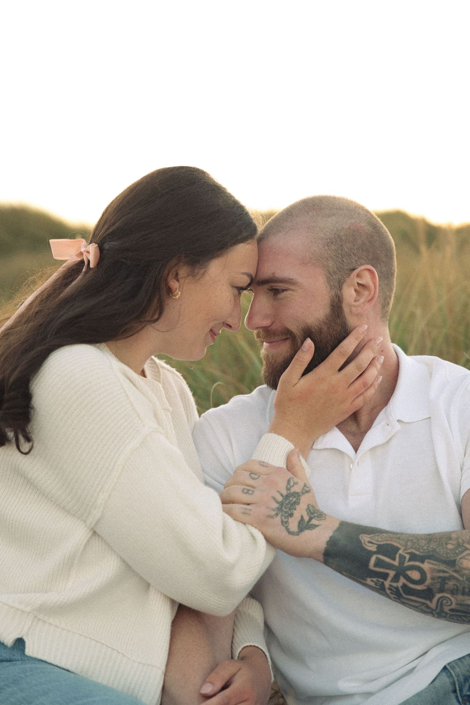 Tender moment shared between couple in white sweater and casual wear.