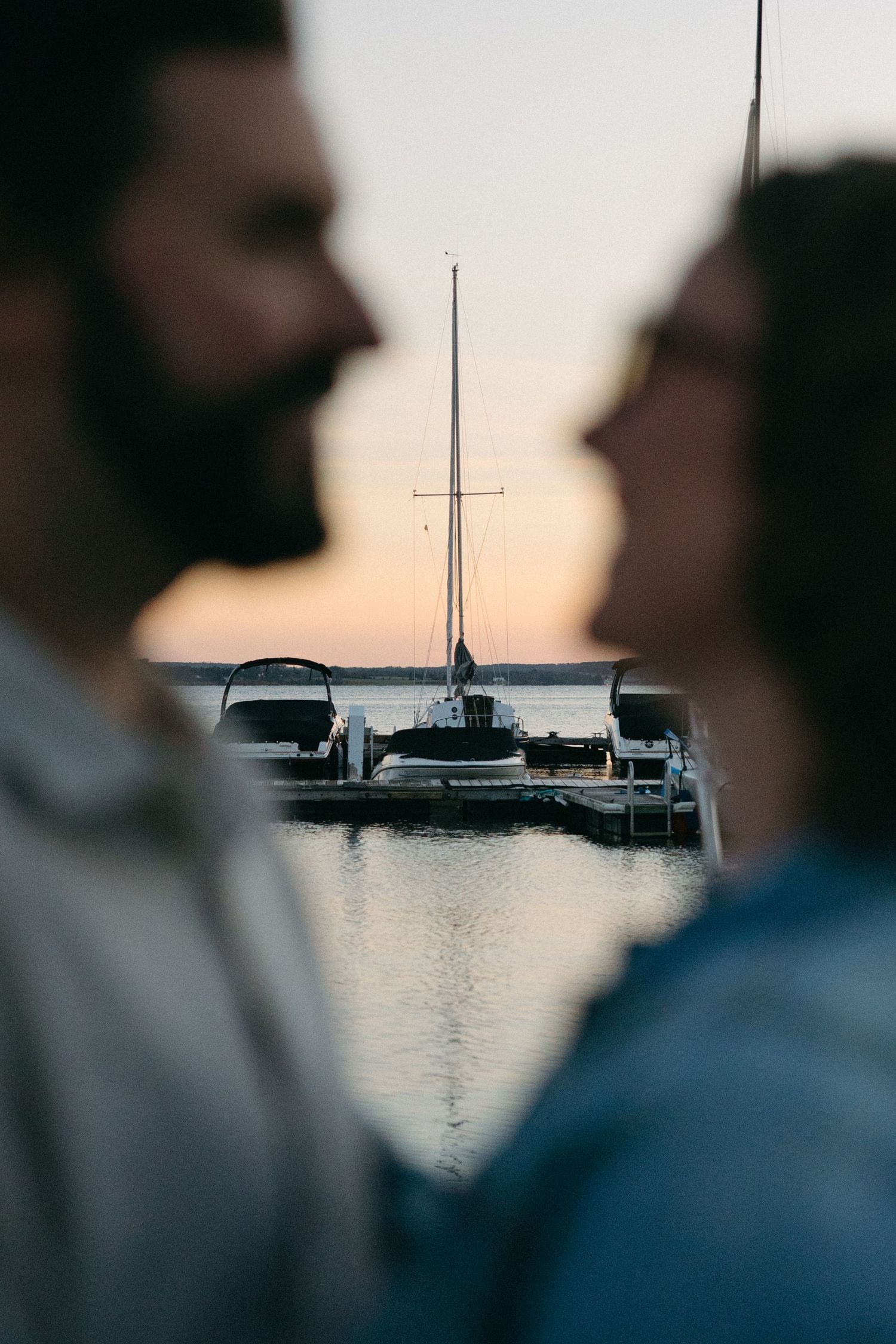 Silhouettes of boats at sunset on calm waters.