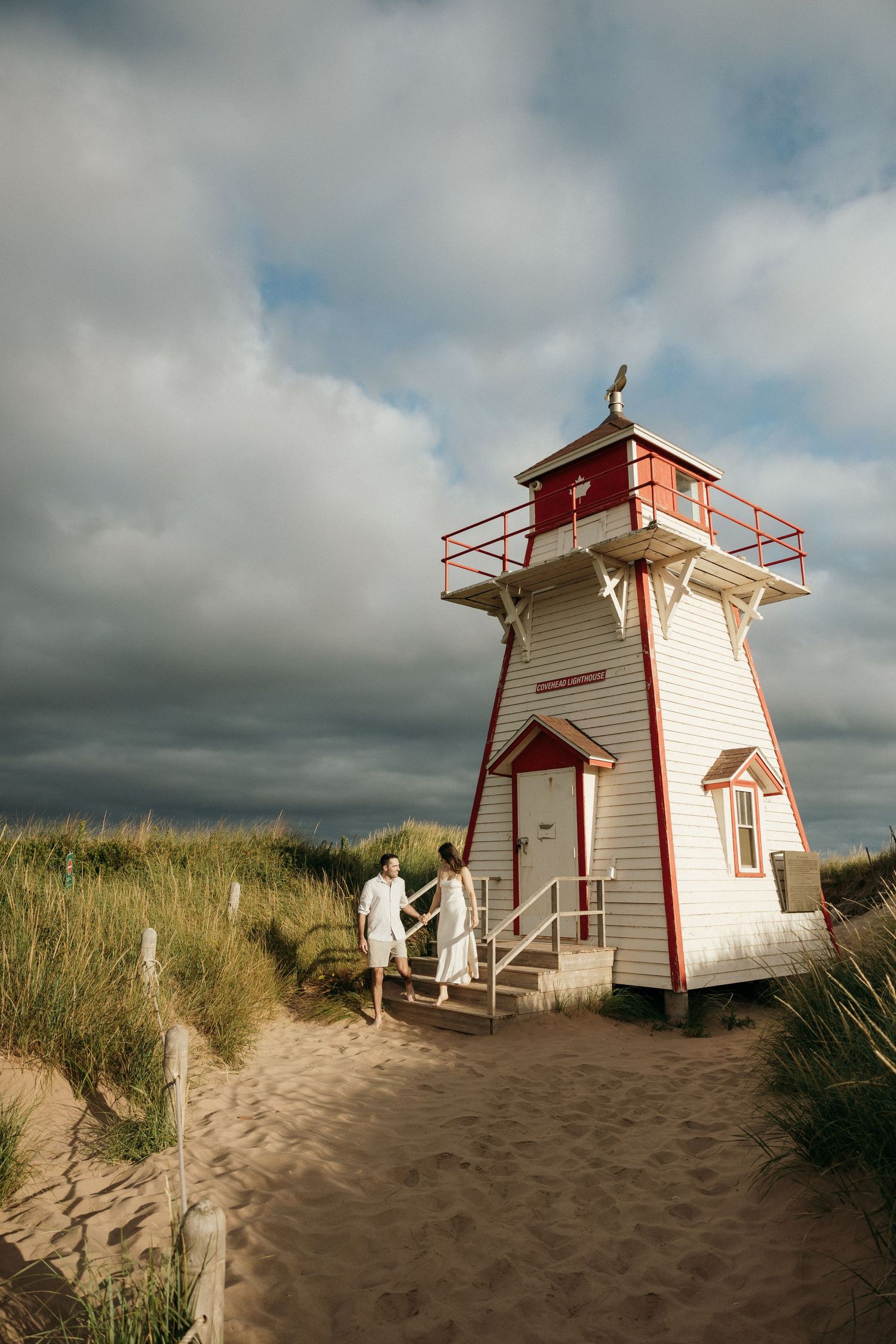 Multiple views of a charming white and red lighthouse on sandy dunes with beach grass.