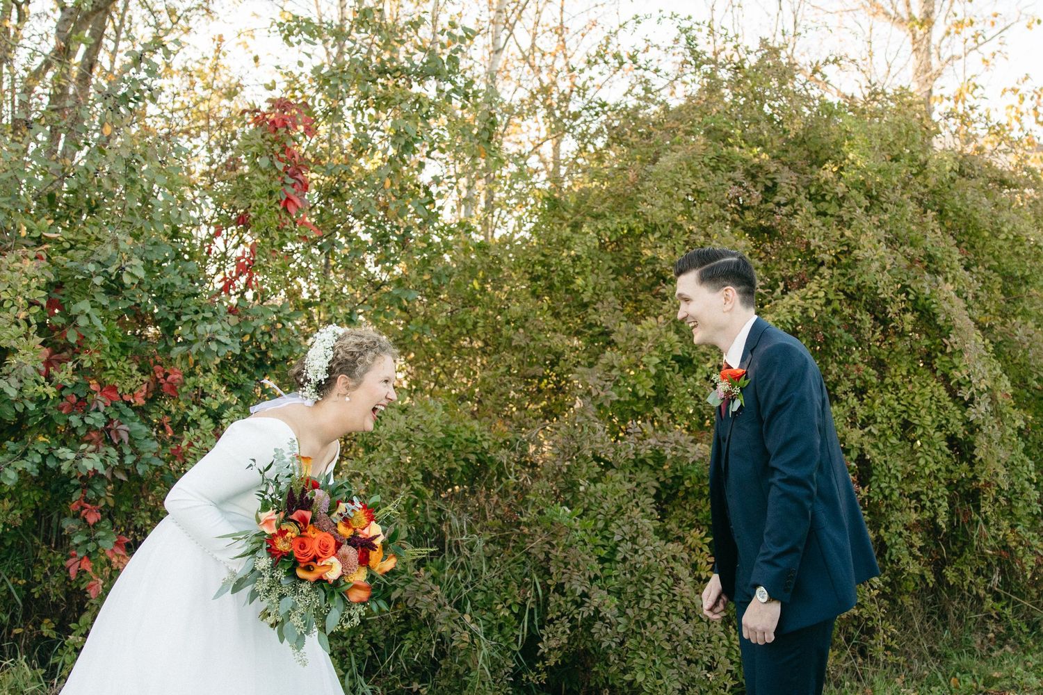 Wedding couple's first look progression captured against autumn trees and red berries.