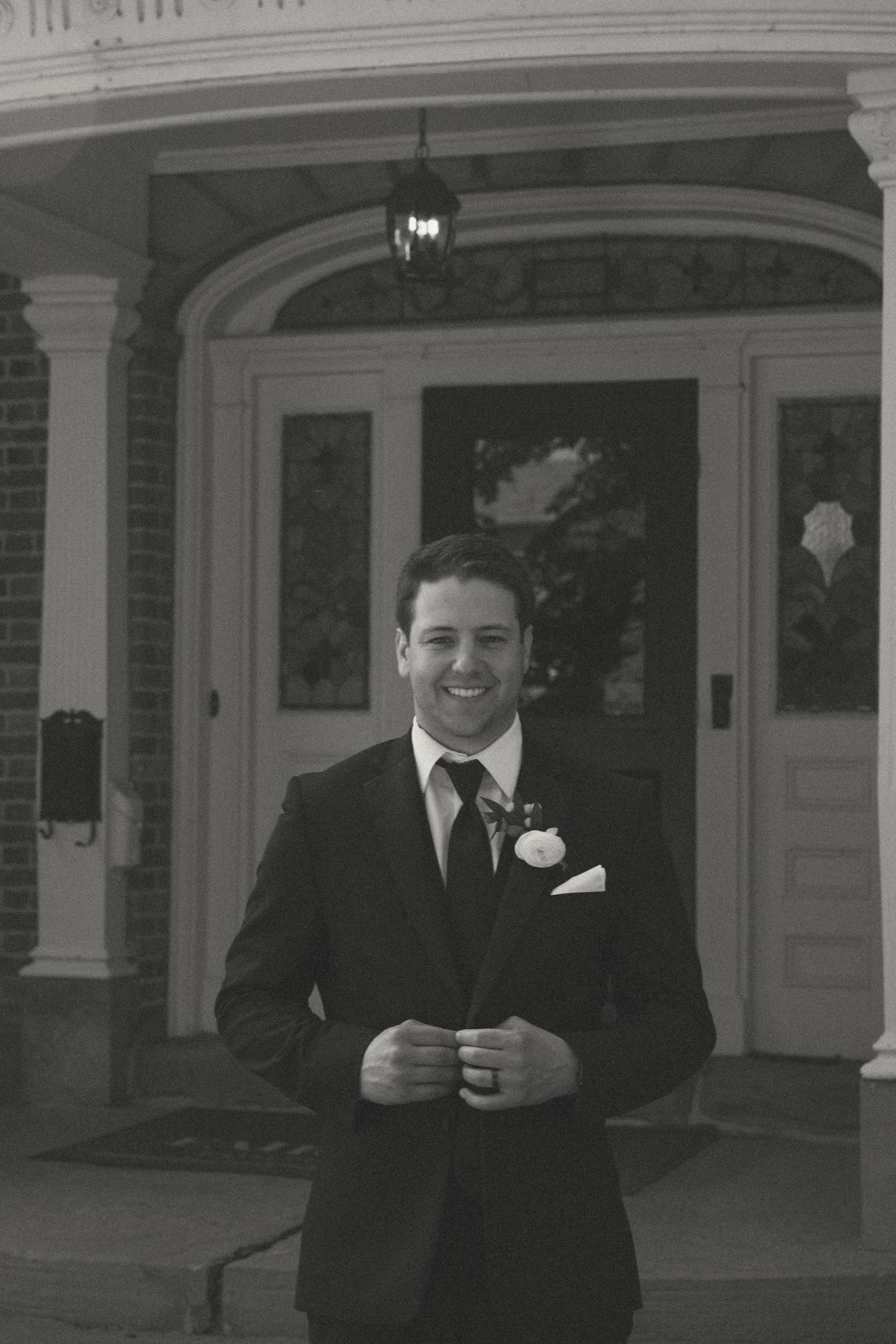 Classic black and white portraits taken on the front porch of a historic building.