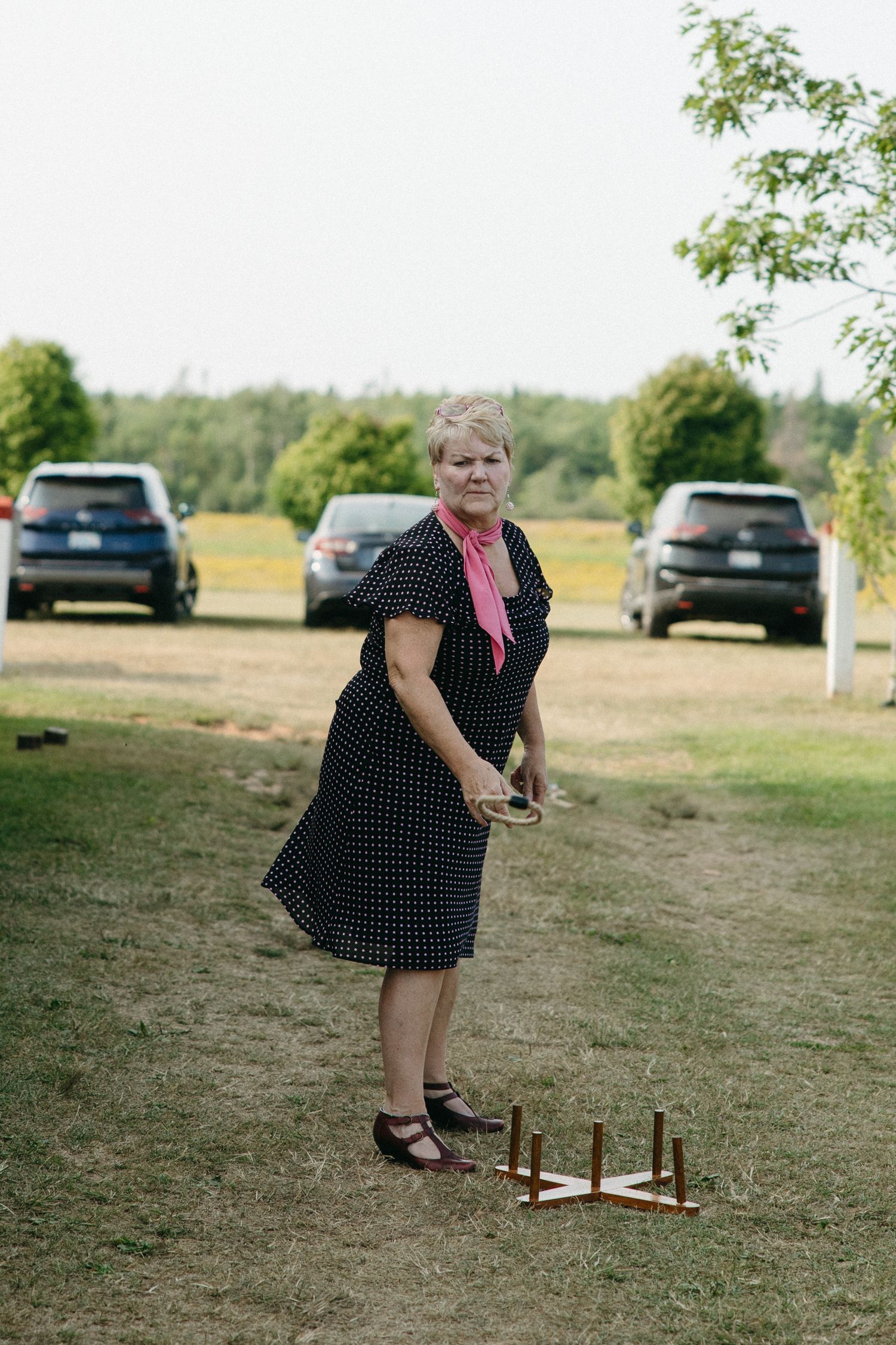 Person in polka dot dress playing lawn games at outdoor event.