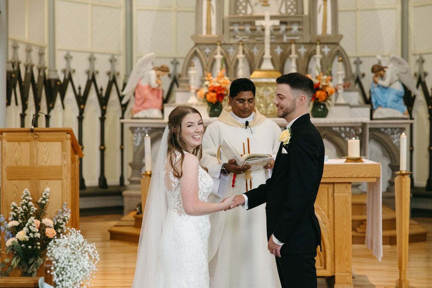Wedding ceremony in a traditional church with Gothic architecture and floral decorations.