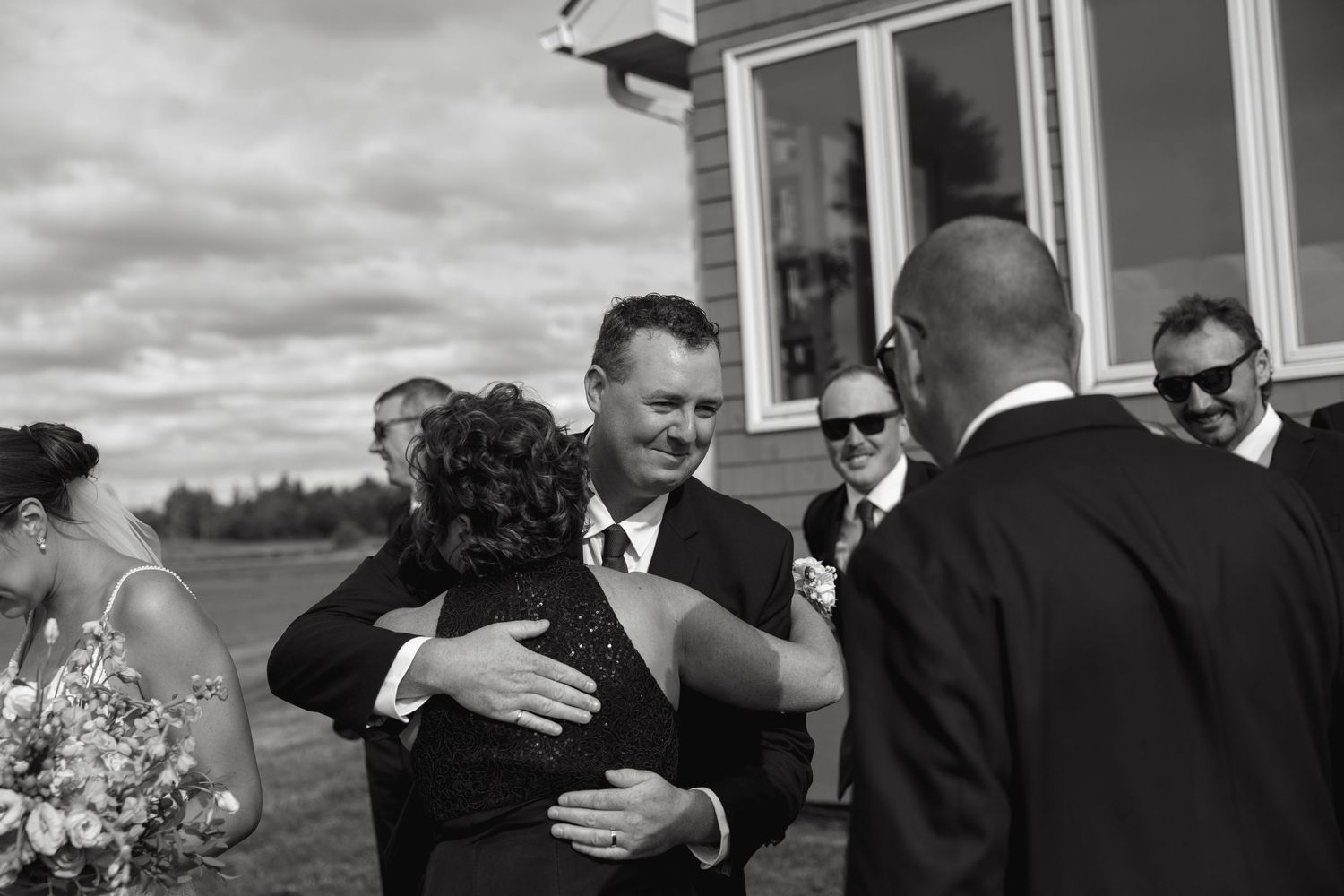 Guests sharing emotional embraces during wedding celebration moments.
