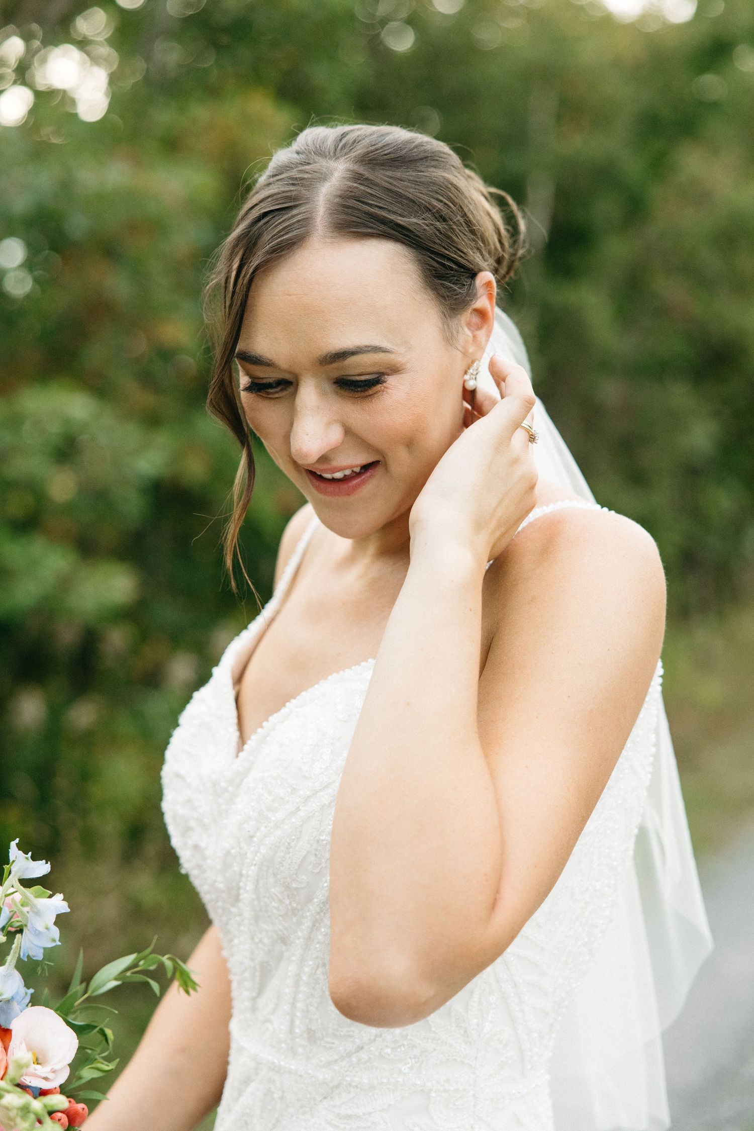 Elegant bridal portrait showcasing lace wedding dress details in natural outdoor setting.