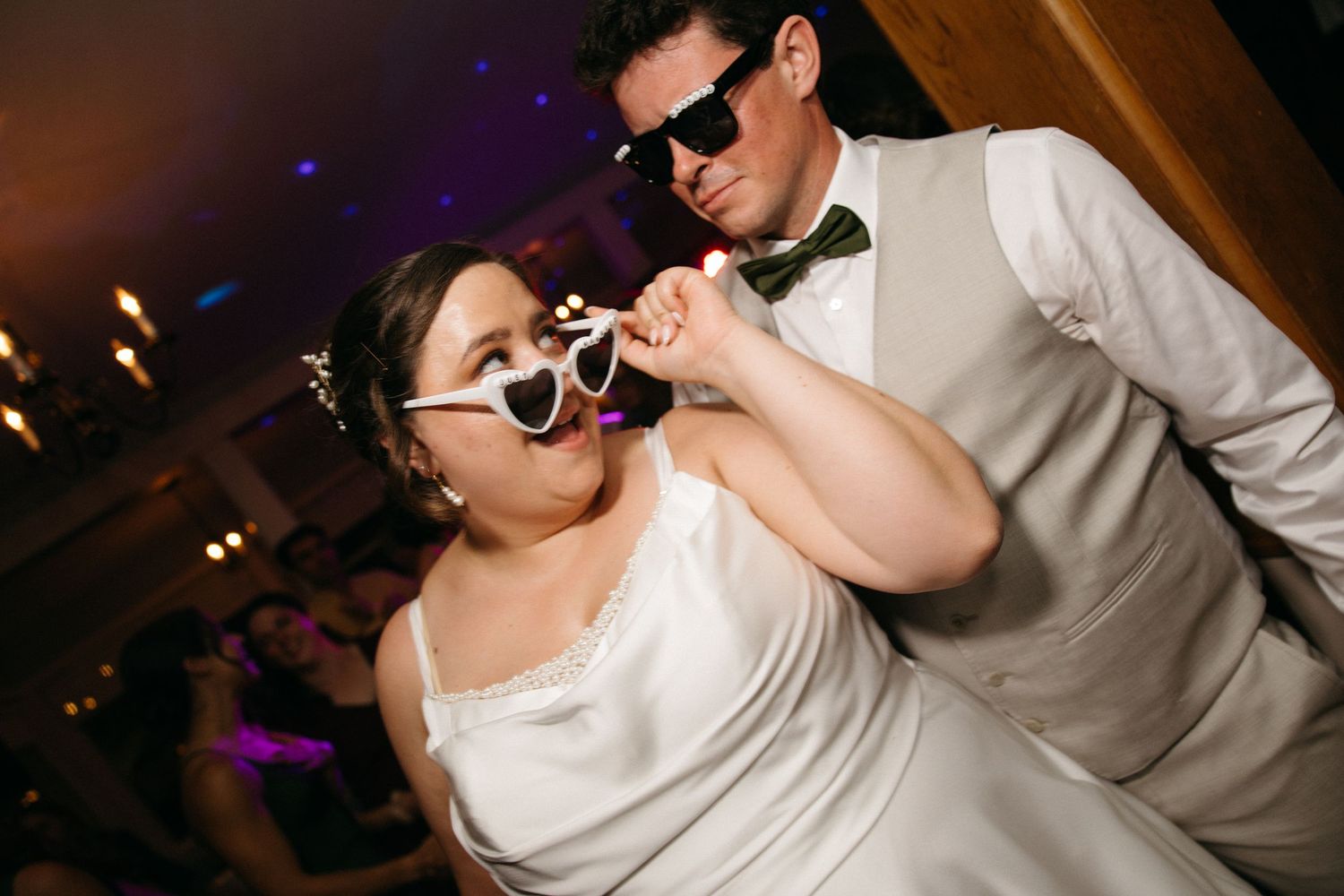 Bride and groom dancing with fun novelty sunglasses at wedding reception party.