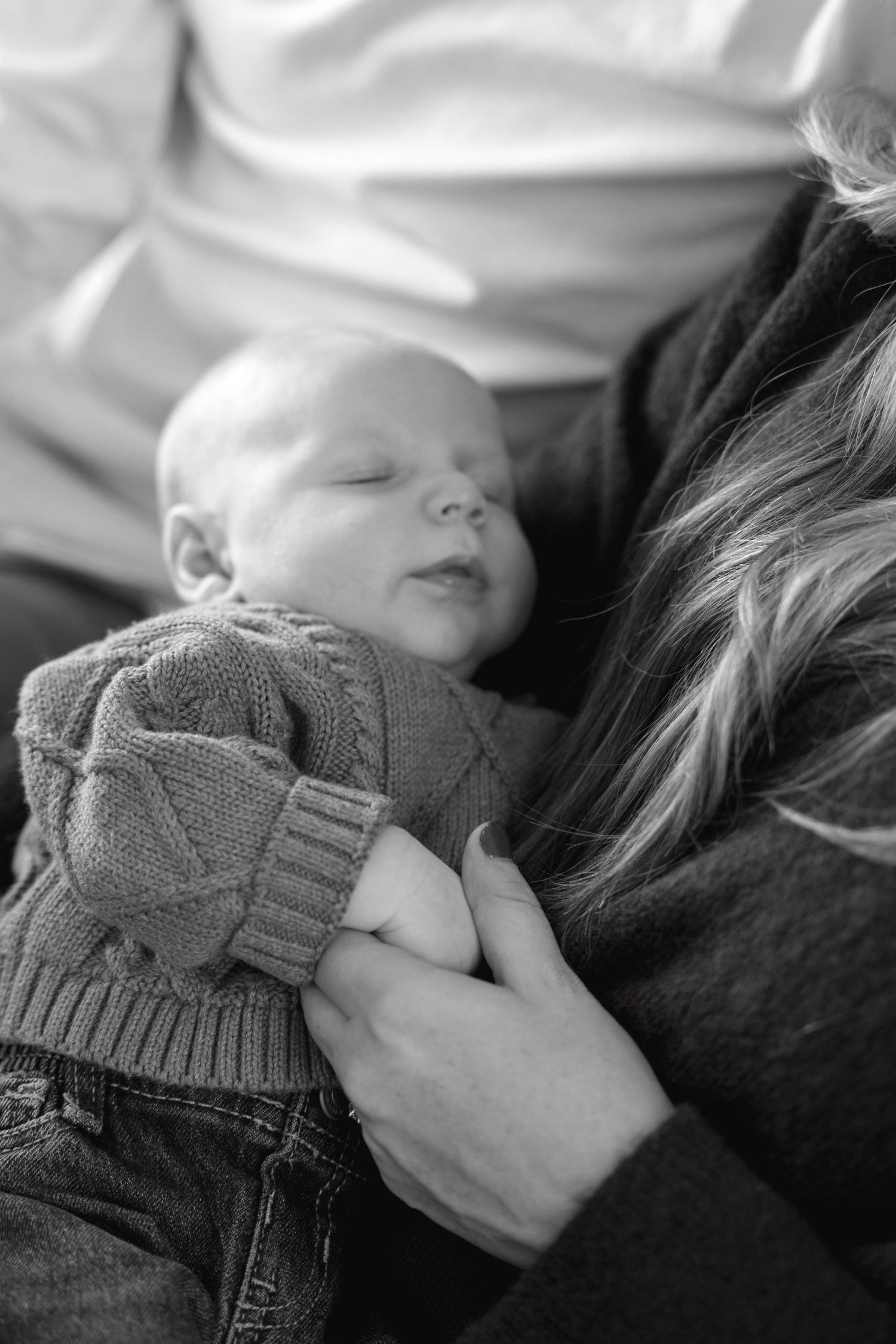 Peaceful black and white image showing someone resting in a gray knit sweater.