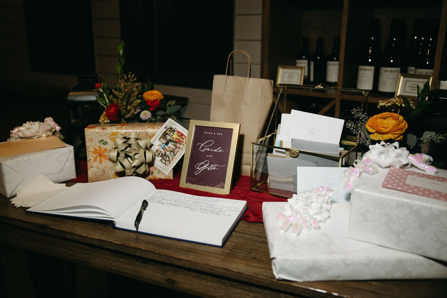 Wedding reception table decorated with cards, frames and floral arrangements.