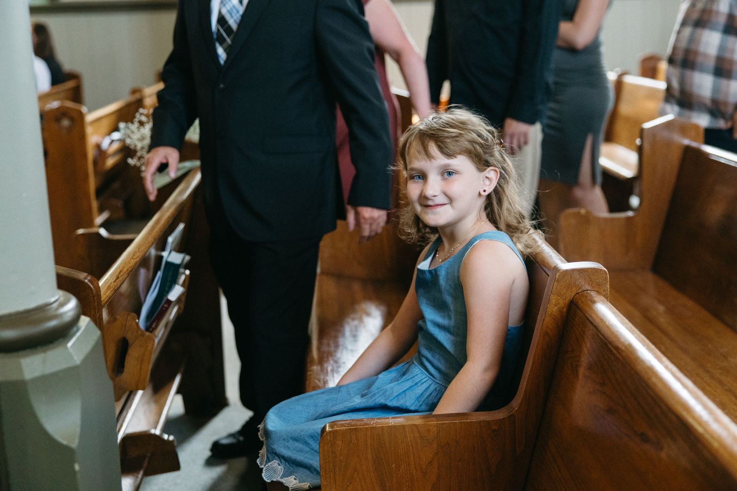 Wedding guests seated in church pews during ceremony.