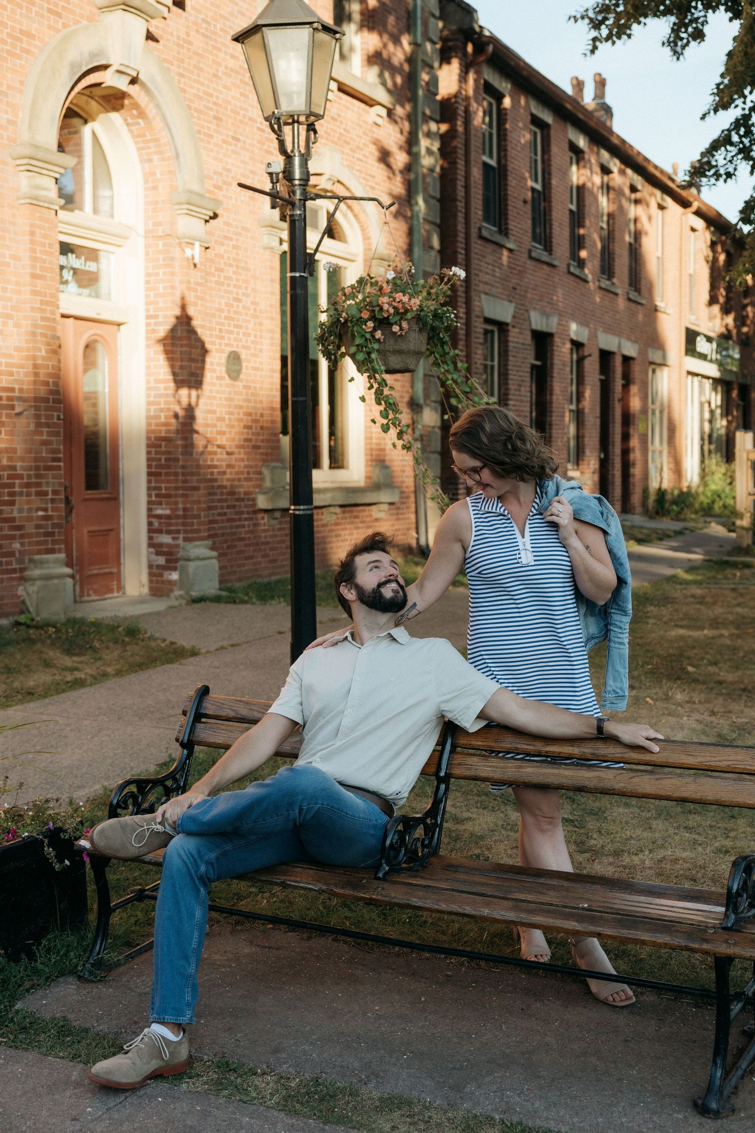 Candid moments of a couple relaxing on a bench near vintage lampposts.