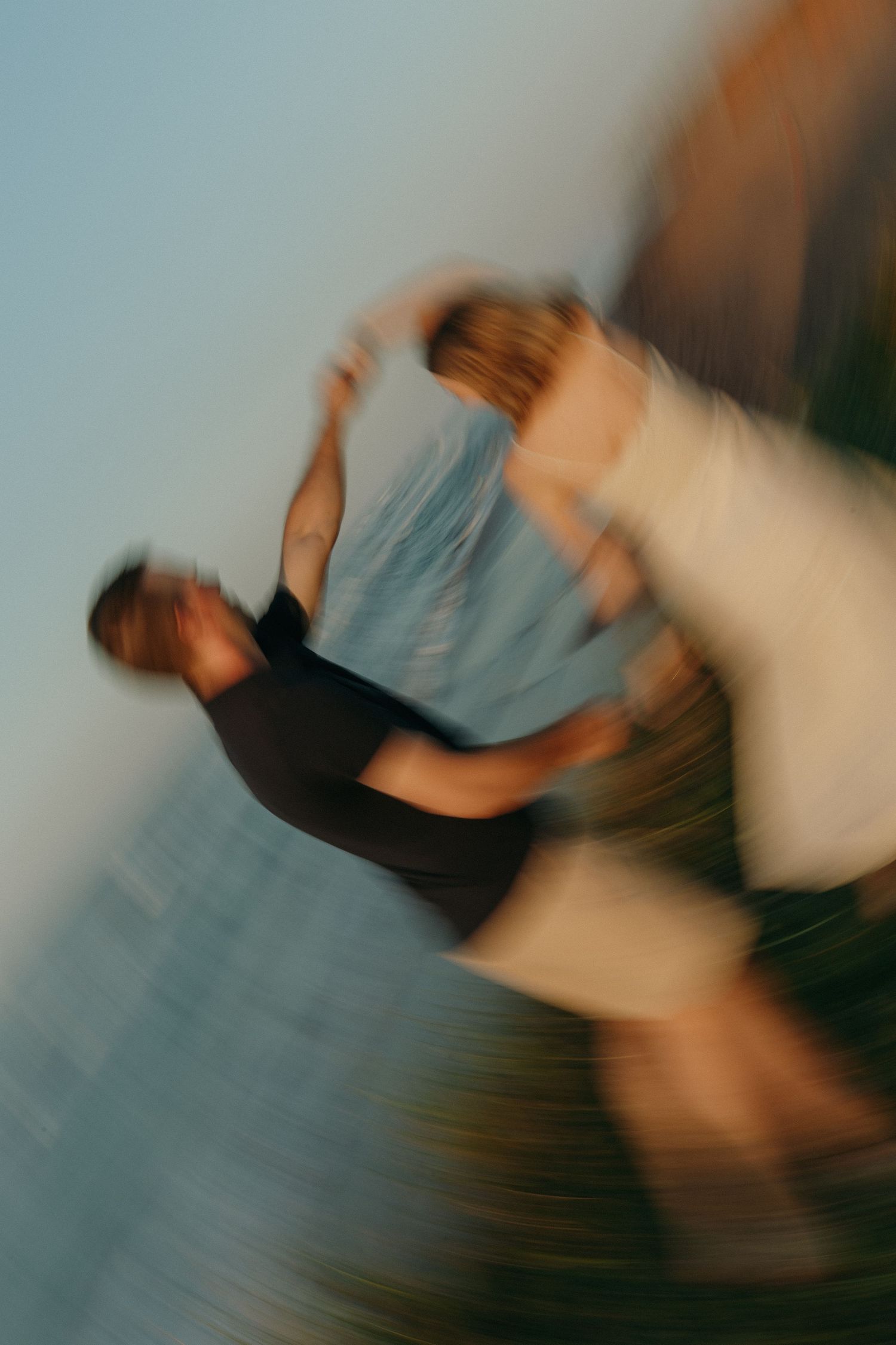 Artistic motion blur photo of a dancing couple on a coastal cliff.