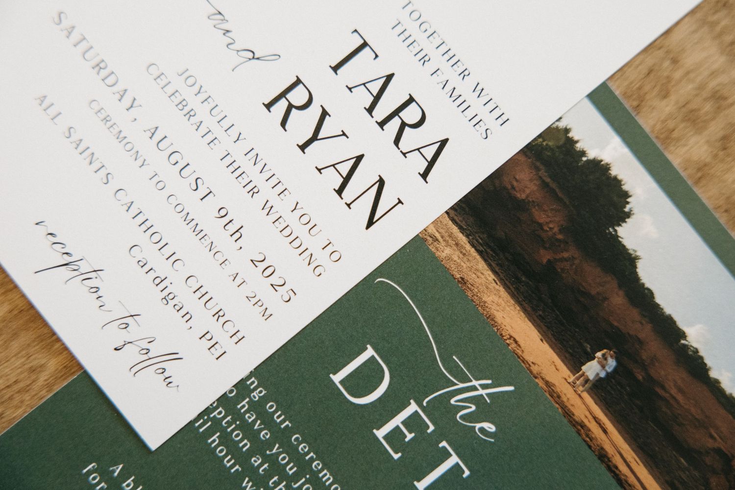 Close-up of elegant wedding stationery with dark green accents.