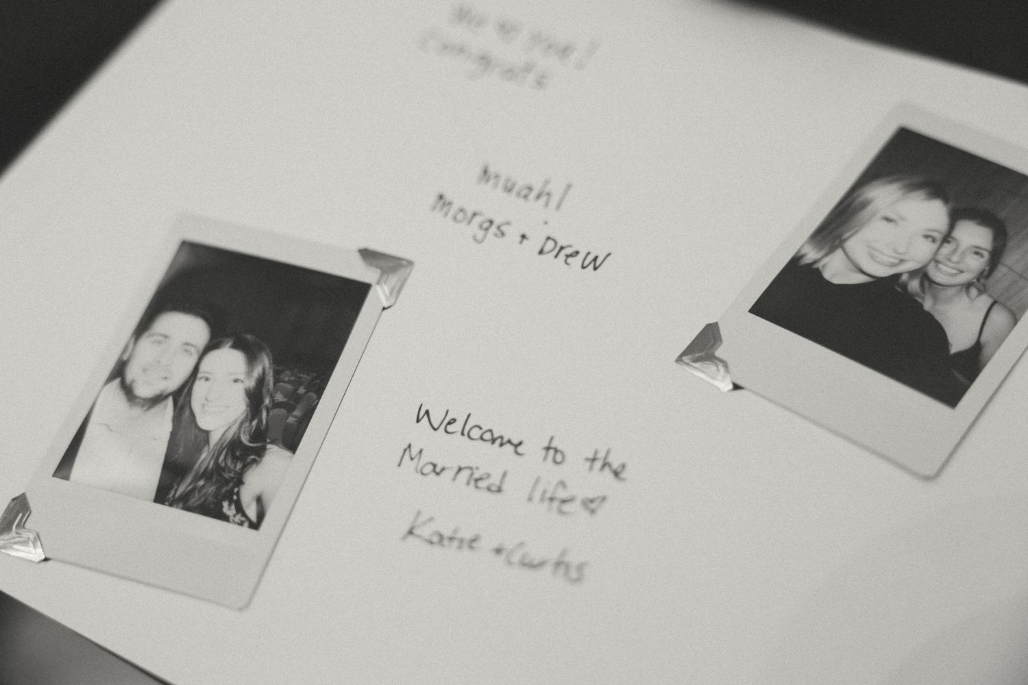 Close-up of a wedding guestbook with black and white polaroid photos.