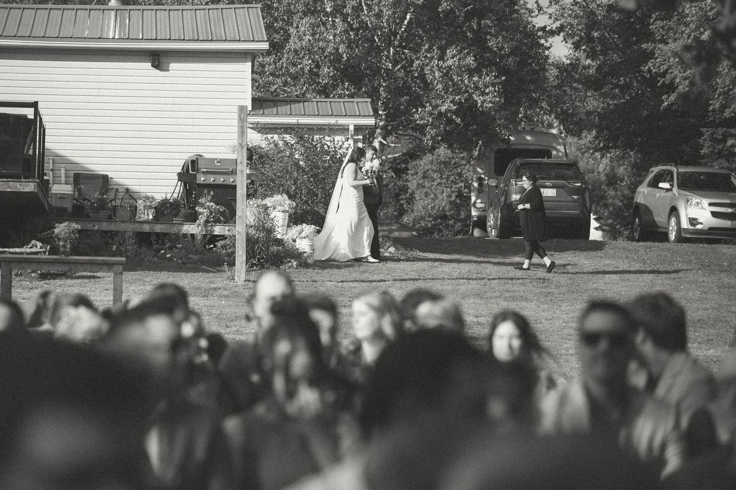 Guests gather outside a white house during a wedding celebration.