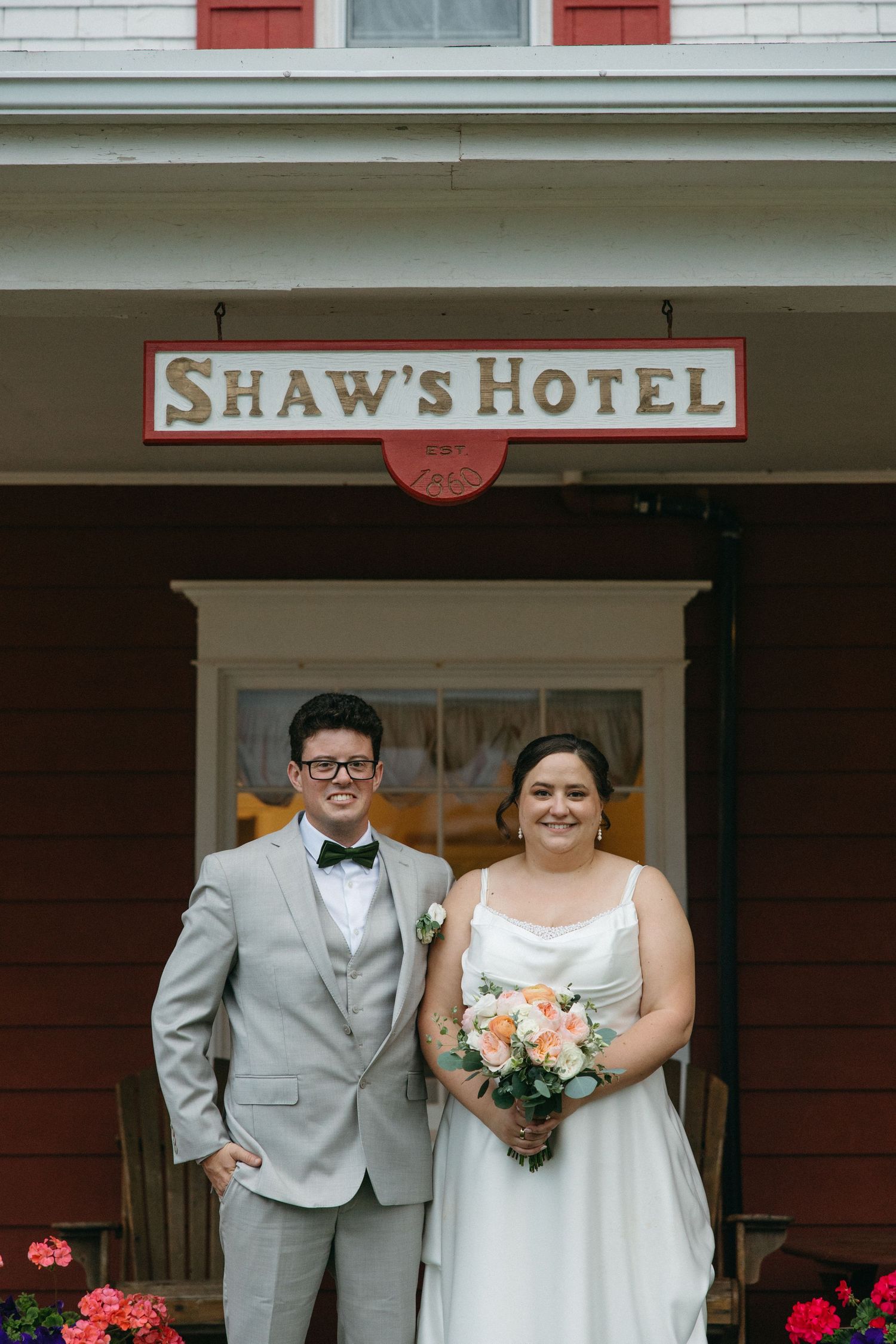 Bride and groom posing together outside Shaw's Hotel on wedding day.