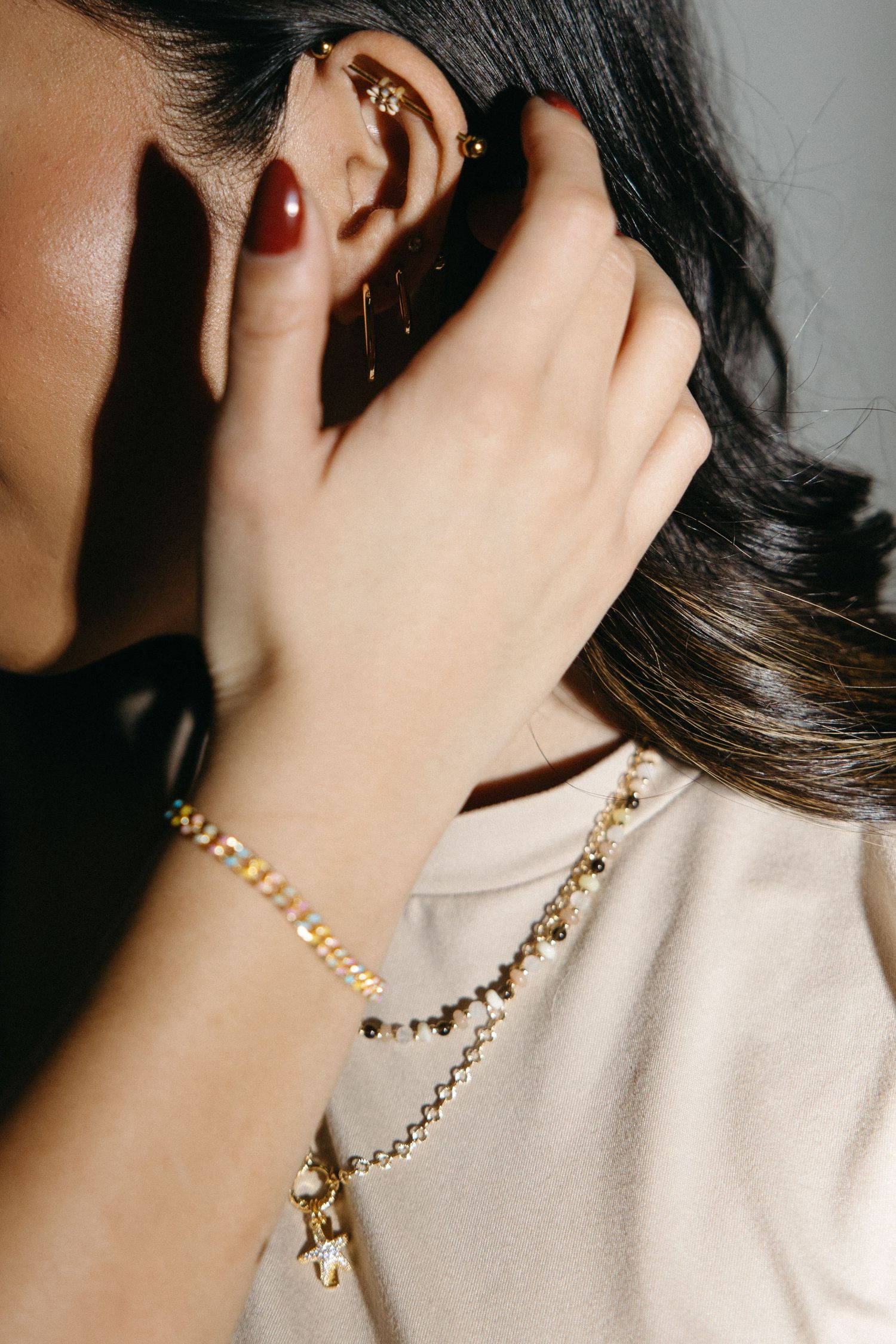 A series of cropped jewelry photos showing gold necklaces and earrings worn against a neutral background.