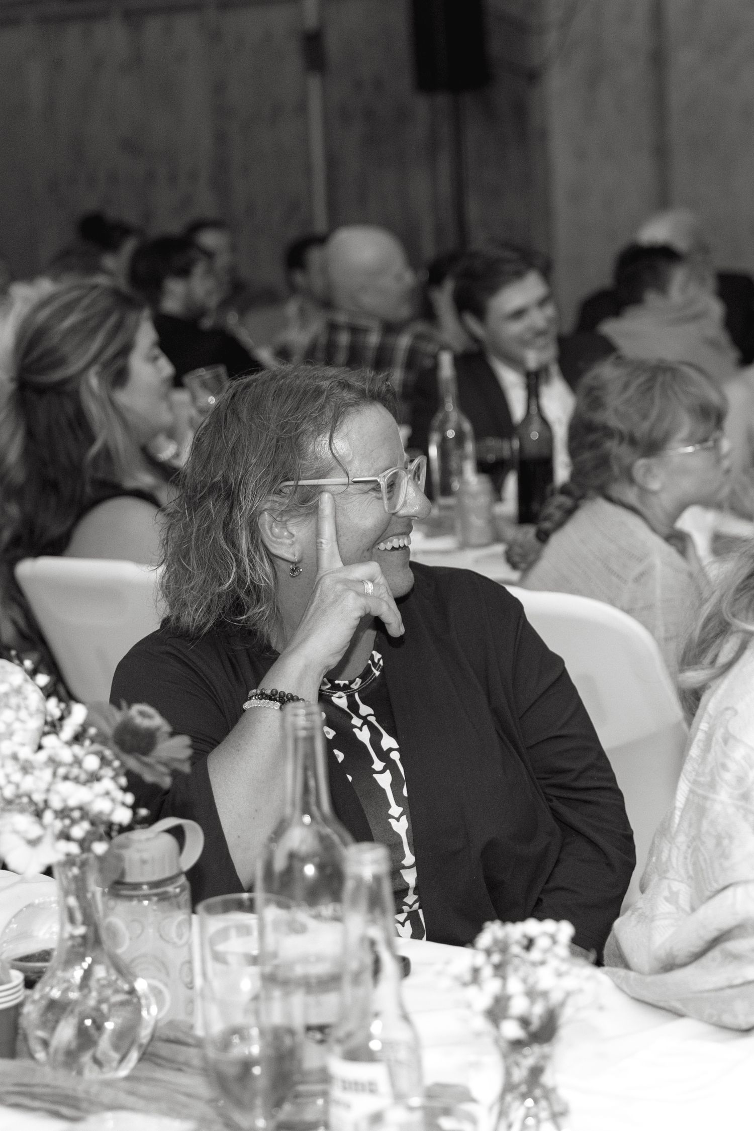 Wedding reception guests seated at decorated tables in black and white.