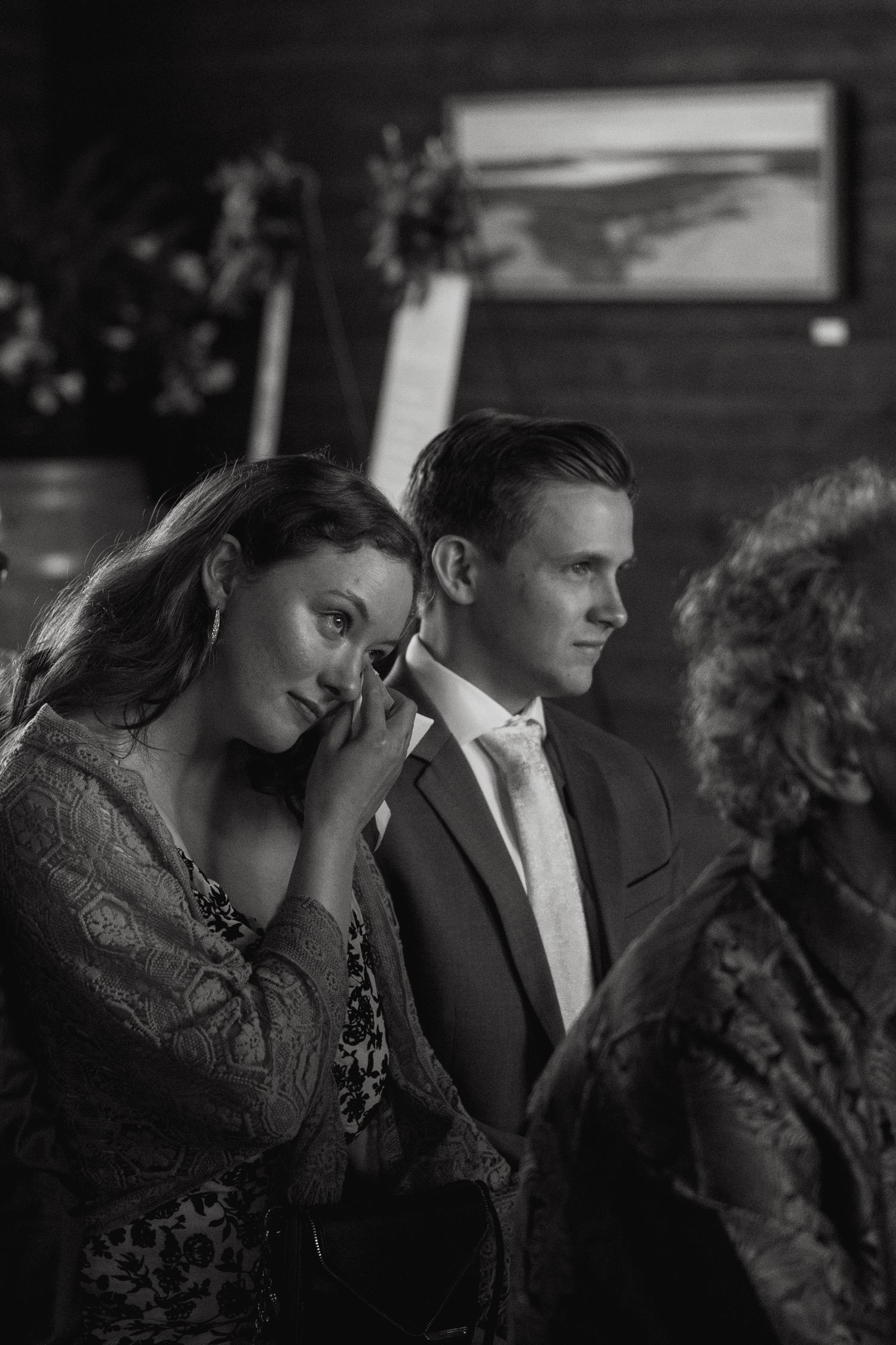 Couple in formal attire sharing an intimate moment in black and white photography.