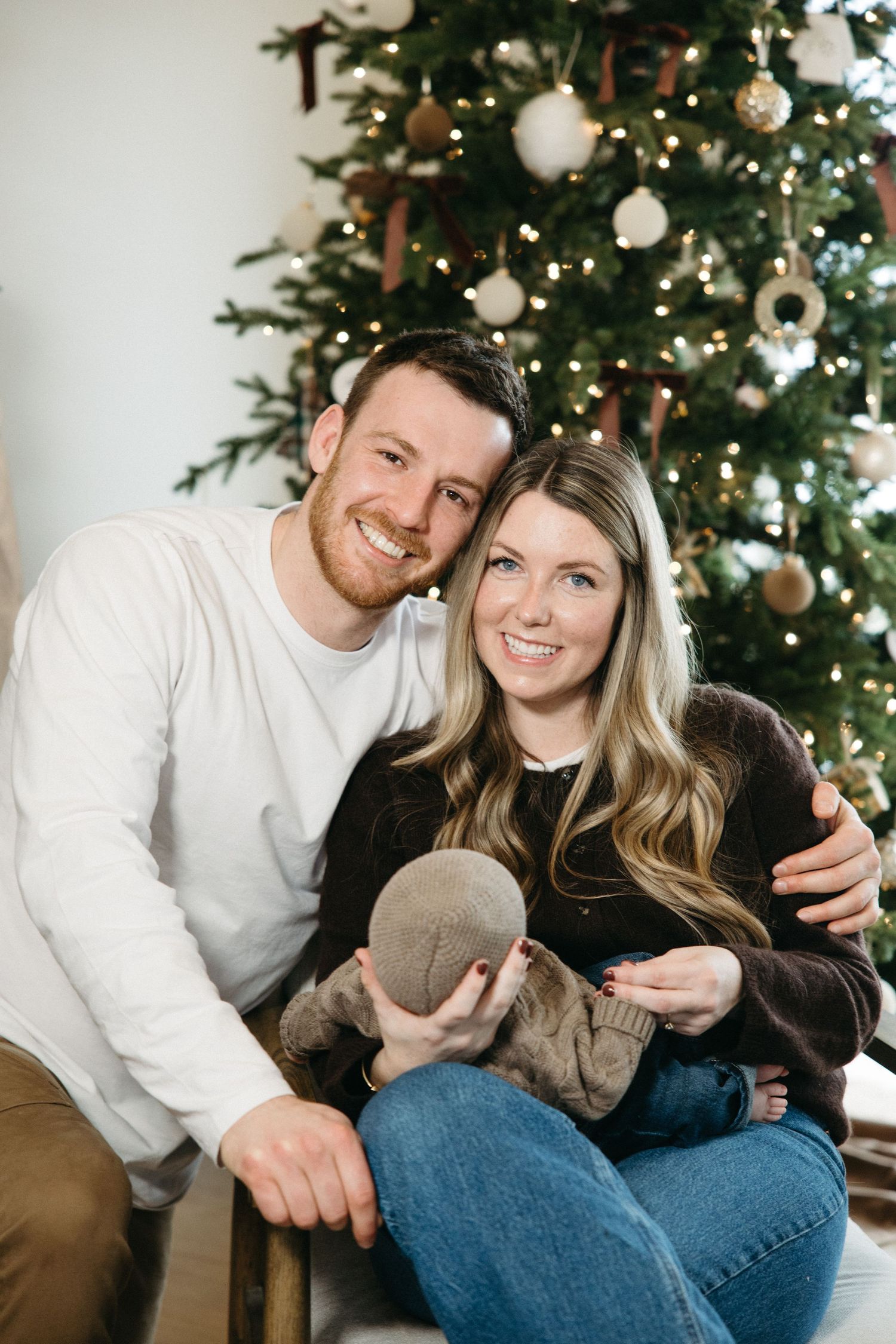 Holiday portraits of a family in front of a decorated Christmas tree.