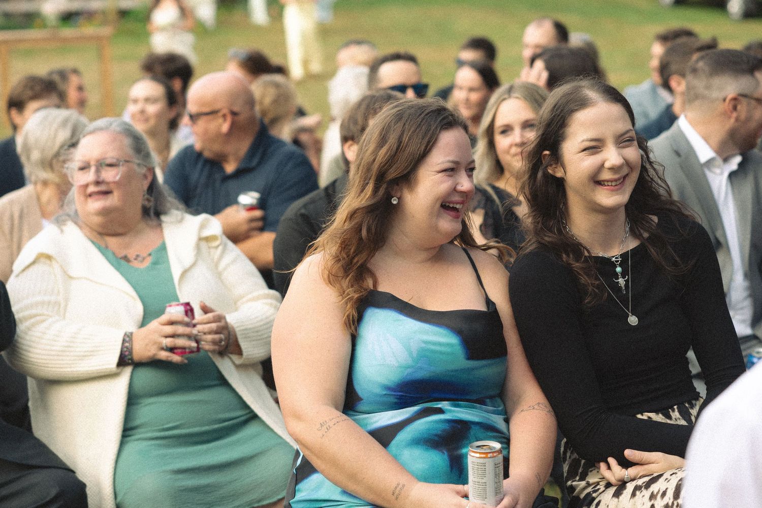 Wedding guests laughing and enjoying themselves during an outdoor reception.
