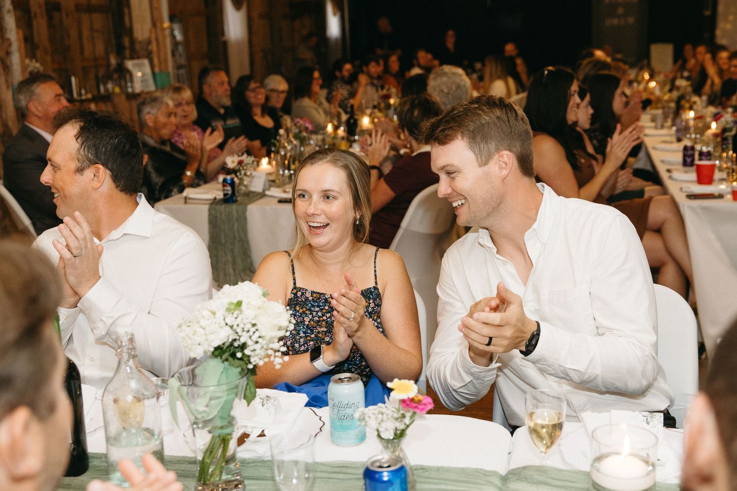 Wedding guests seated at decorated tables during a reception dinner celebration.