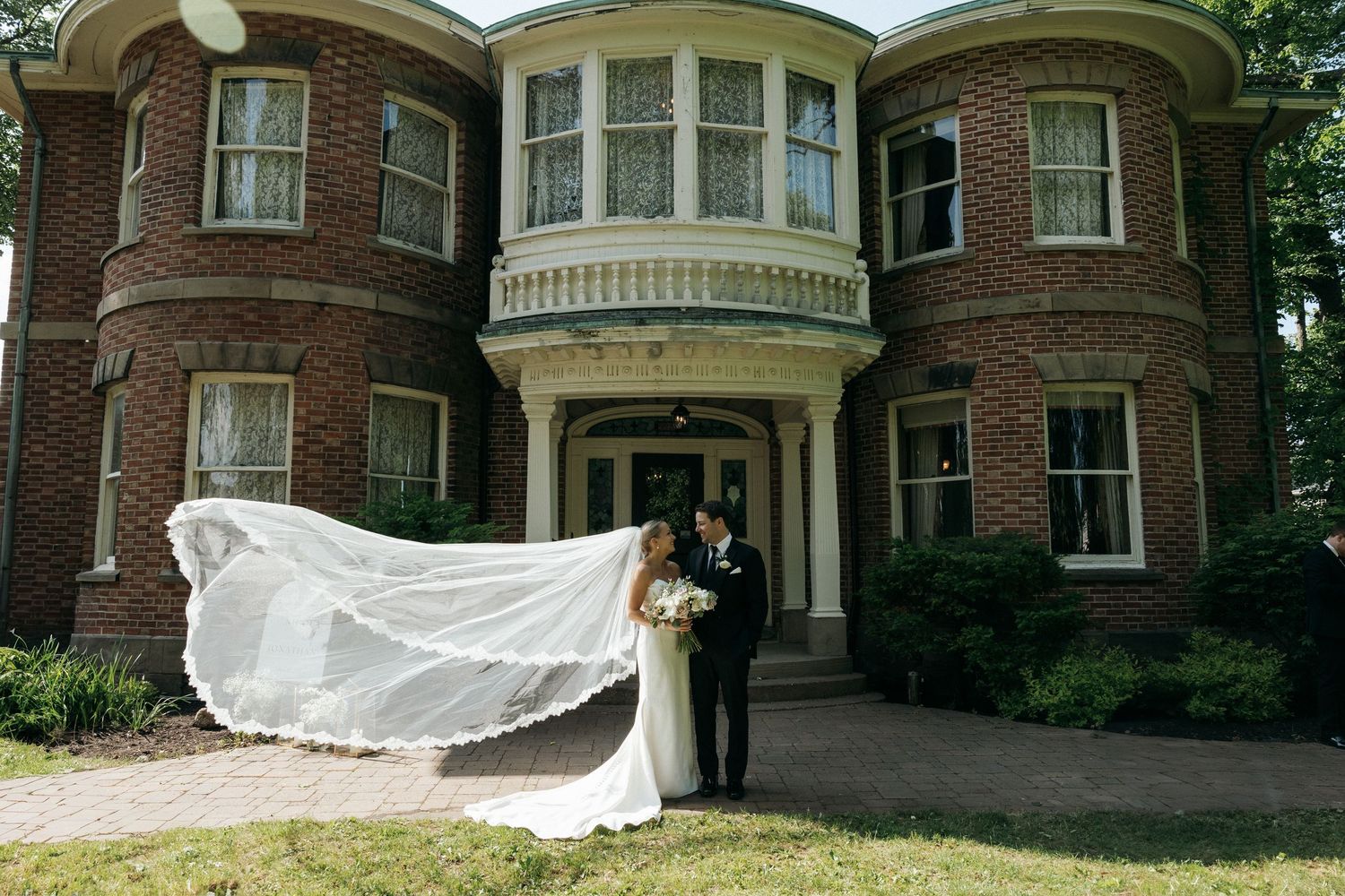 Wedding photos captured outside a grand historic mansion with architectural columns and details.