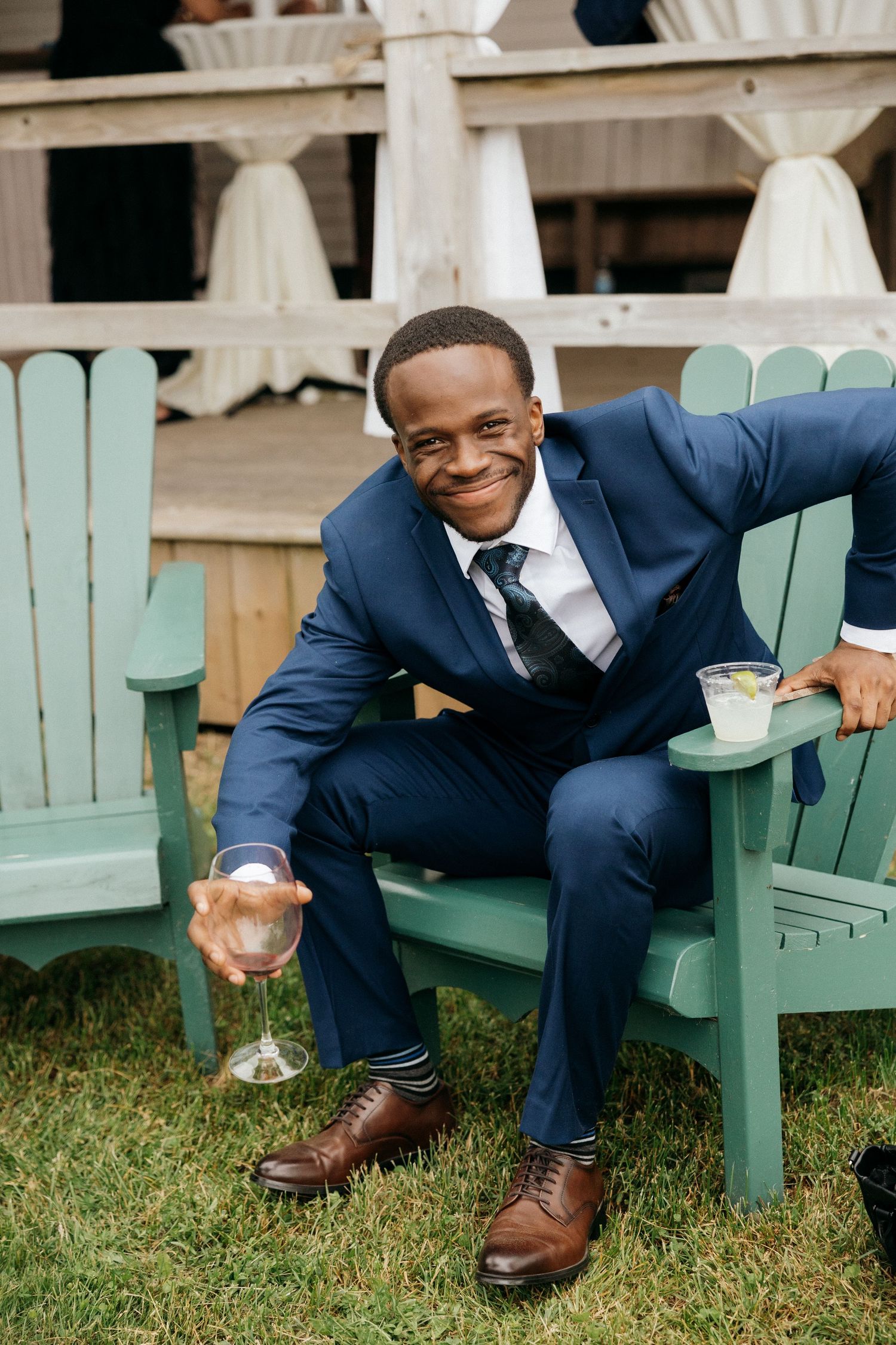 Mint green Adirondack chair on grass with formal event setting.