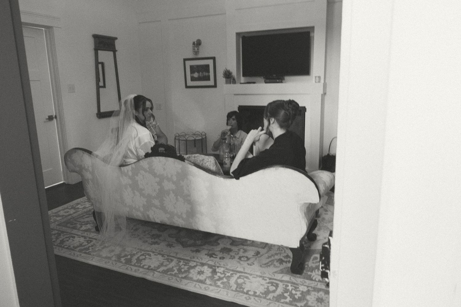 Black and white photos showing preparation moments in a cozy getting-ready room.