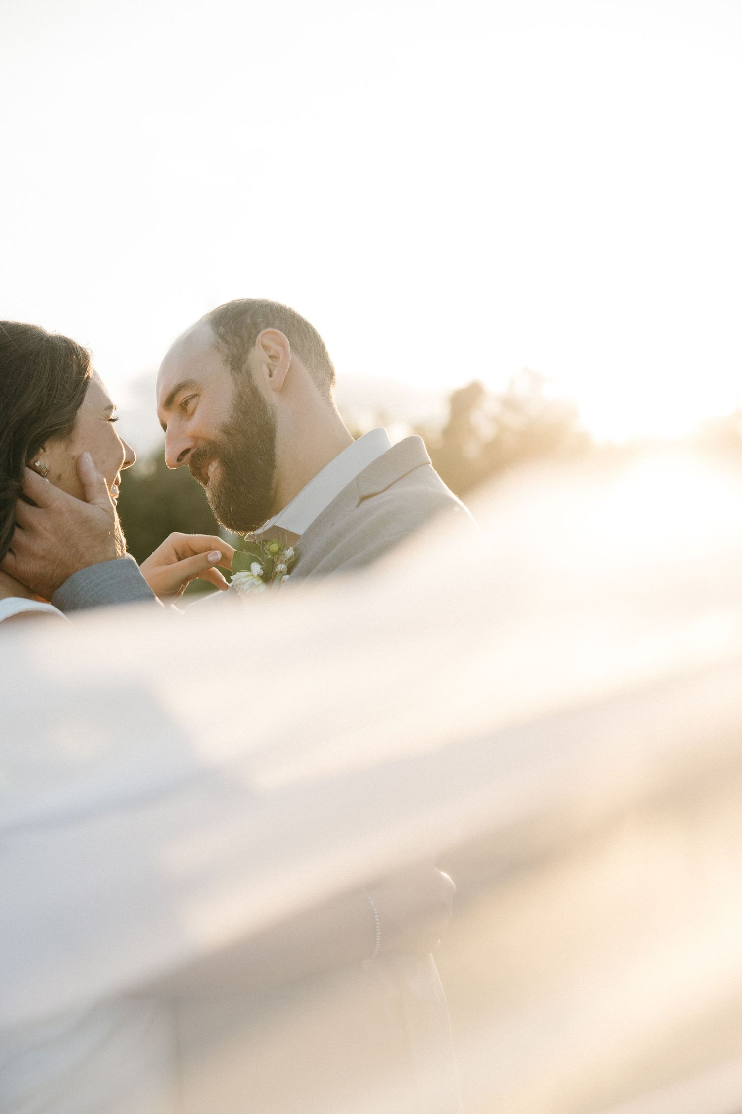 Intimate wedding moment captured in dreamy sunlit photography.