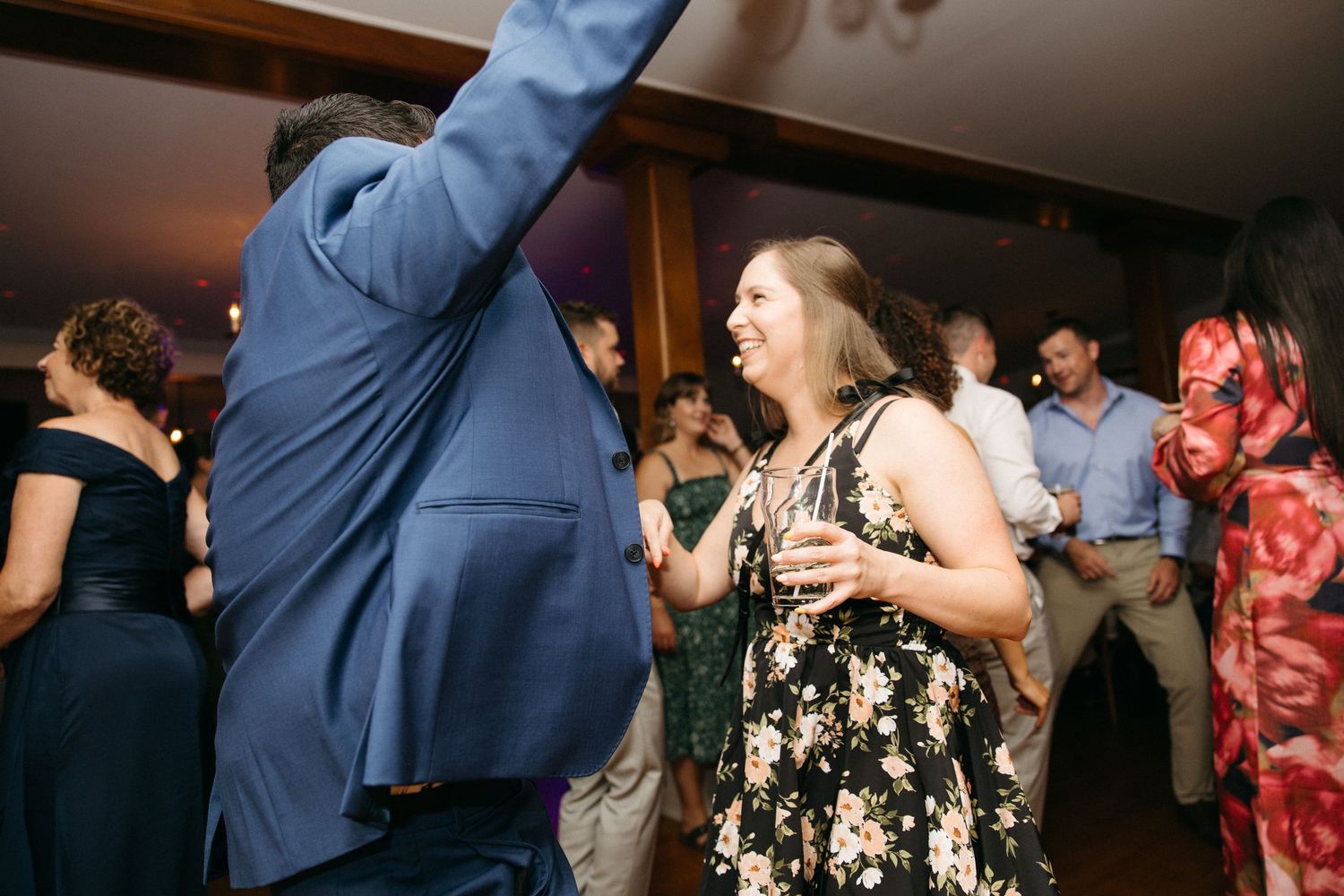 Guests dancing and laughing together at lively wedding reception party.