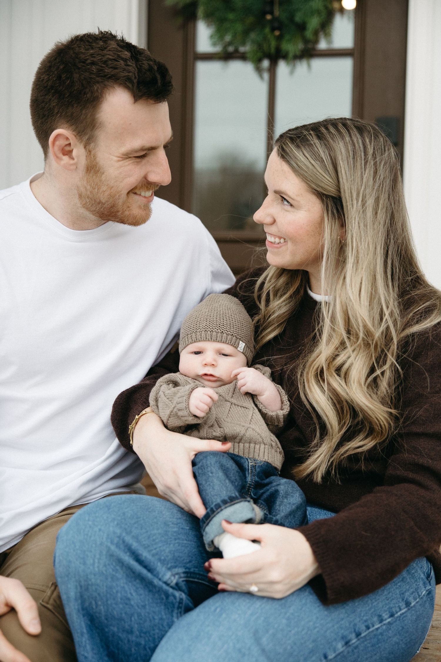 Cozy family moment on white furniture with casual clothing and natural lighting.