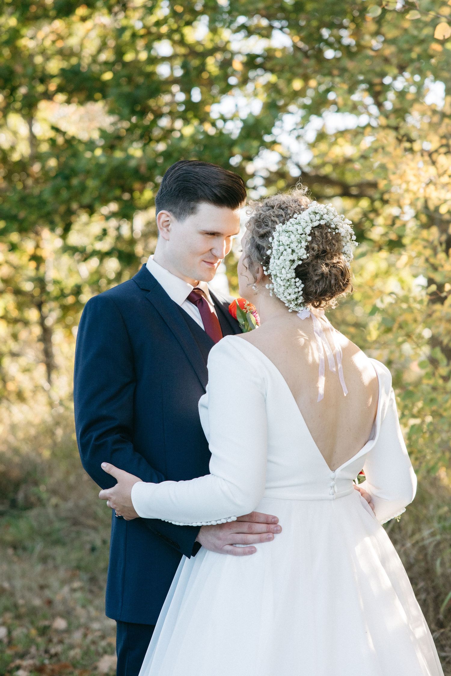 A romantic wedding moment captured between a couple in navy suit and white dress.