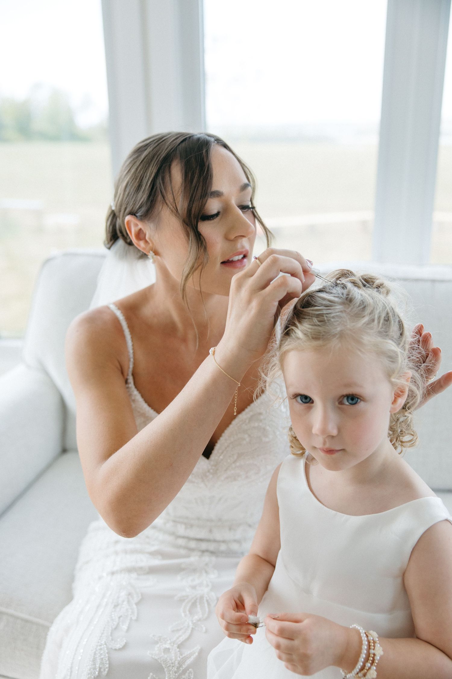Wedding day preparation moment in bright sunlit room.