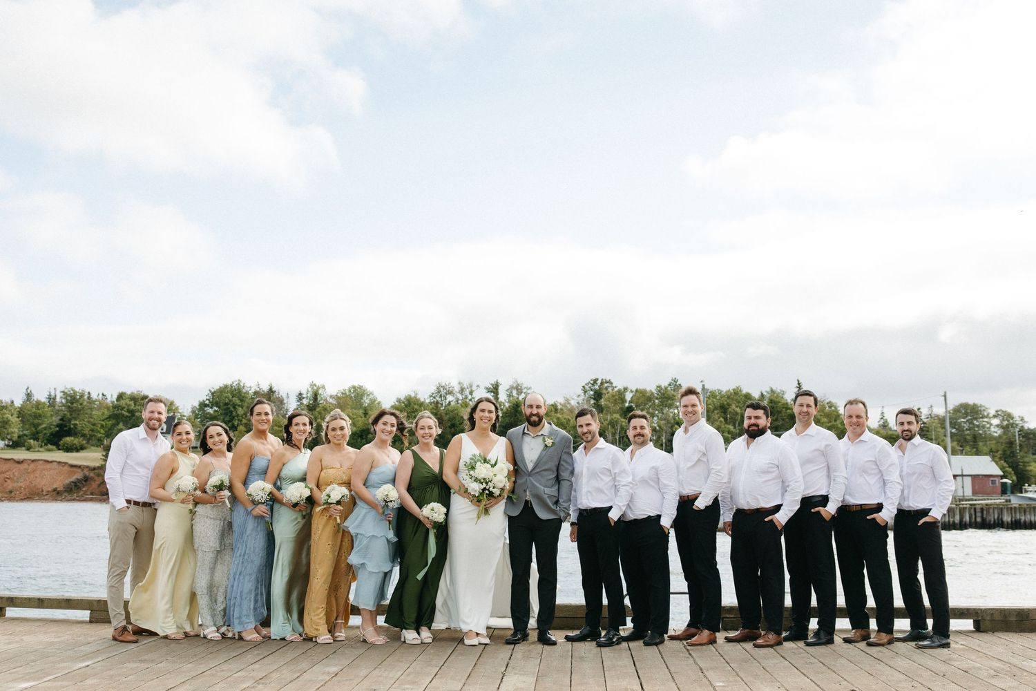 Panoramic shot of entire wedding party lined up by the waterfront.