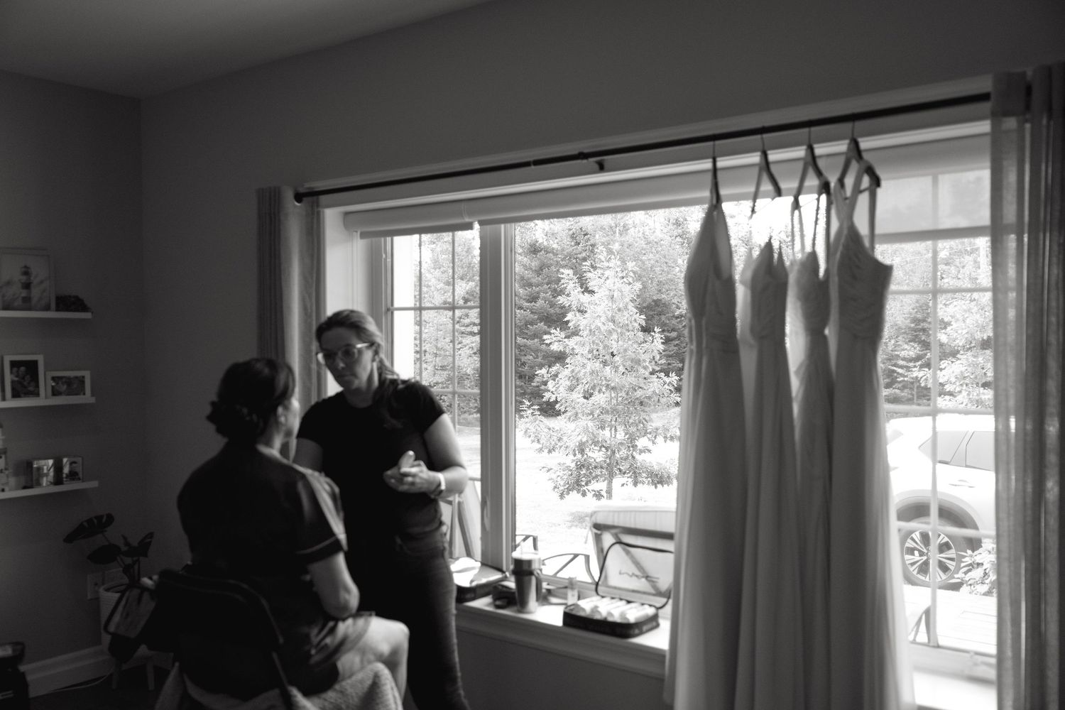 Black and white silhouettes of people by windows in an interior space.