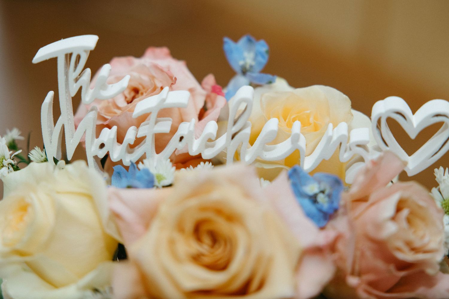 Close-up of delicate peach and blue floral centerpiece arrangements on wedding tables.