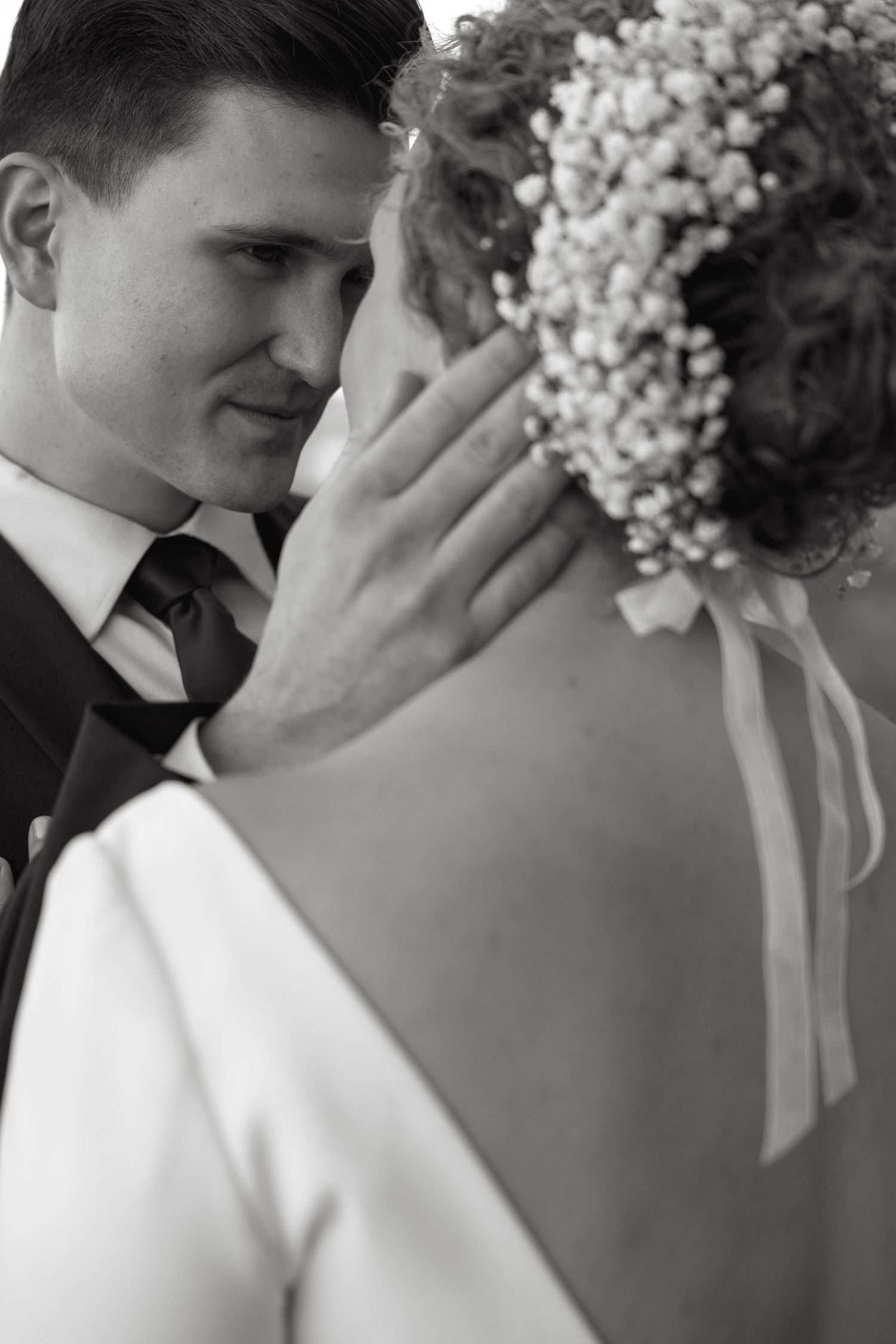 Close-up black and white wedding photo with baby's breath bouquet.