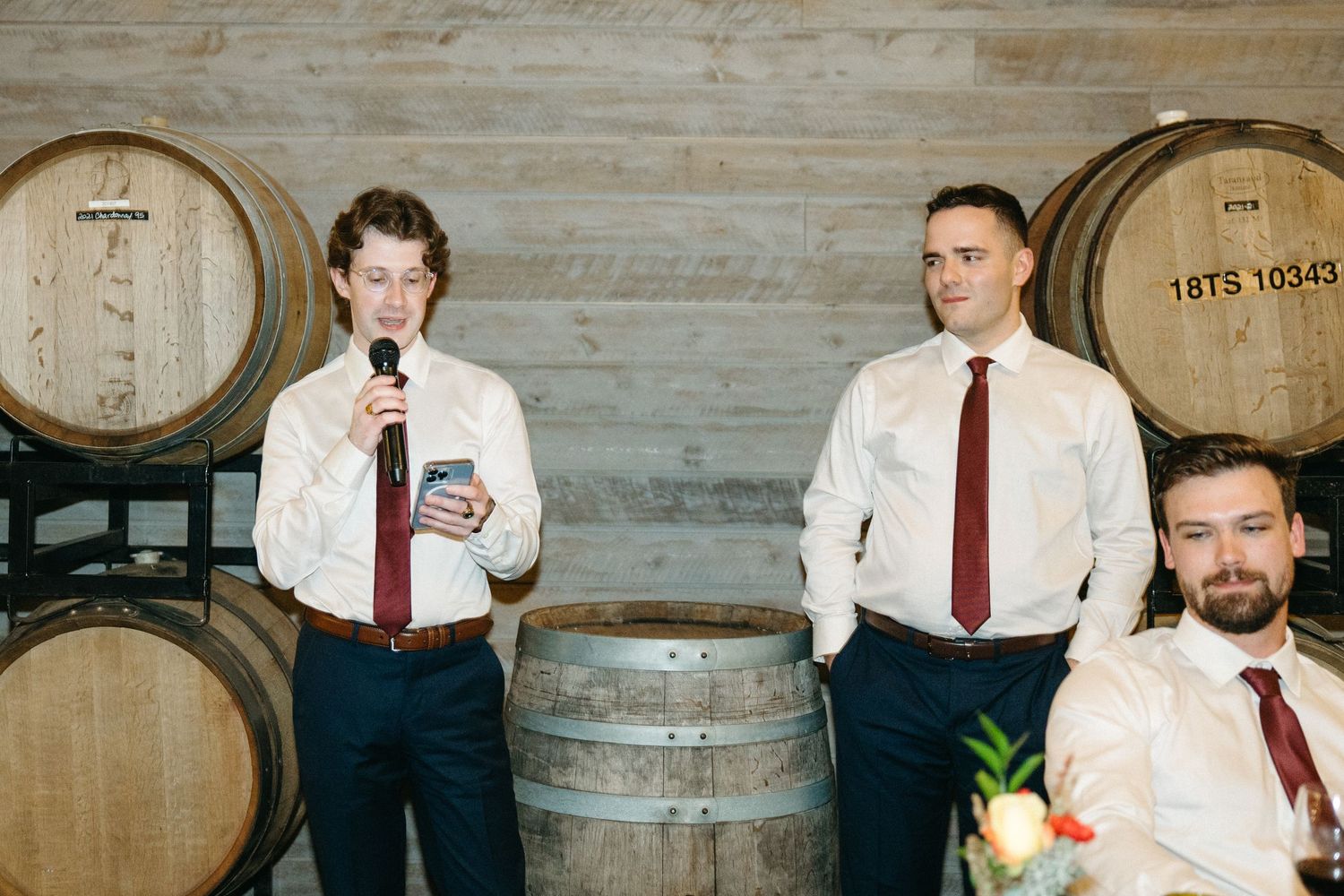 Wine cellar event space with wooden barrels lining the concrete walls.