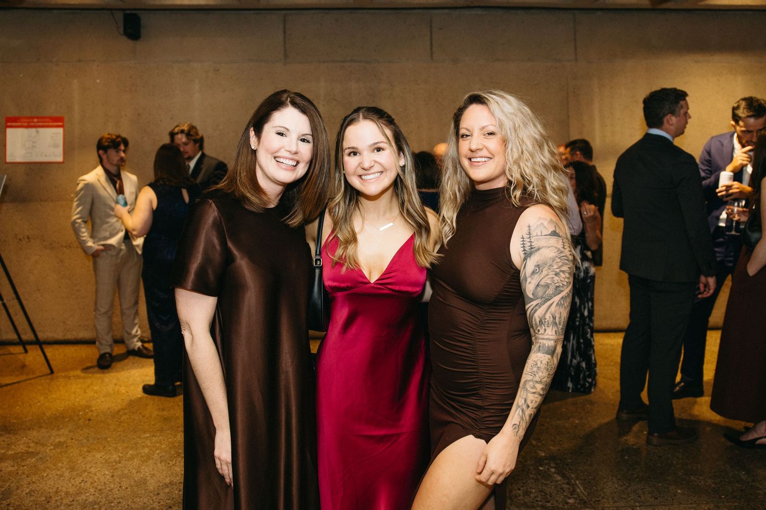 Guests in formal dresses socializing at an elegant evening event.