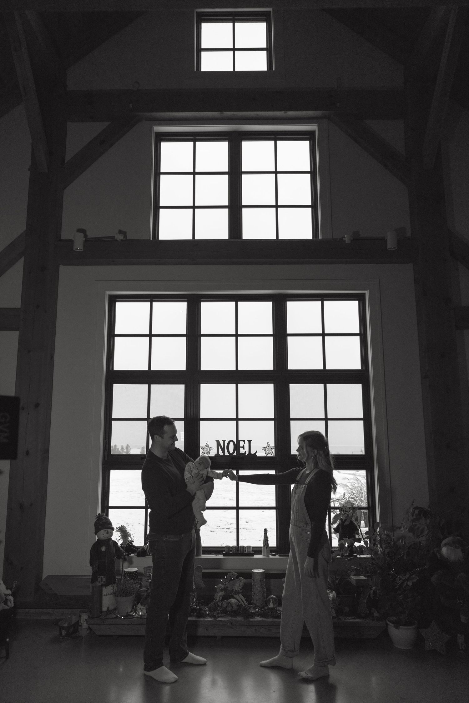 Silhouettes of people gathered in a large room with dramatic window lighting.