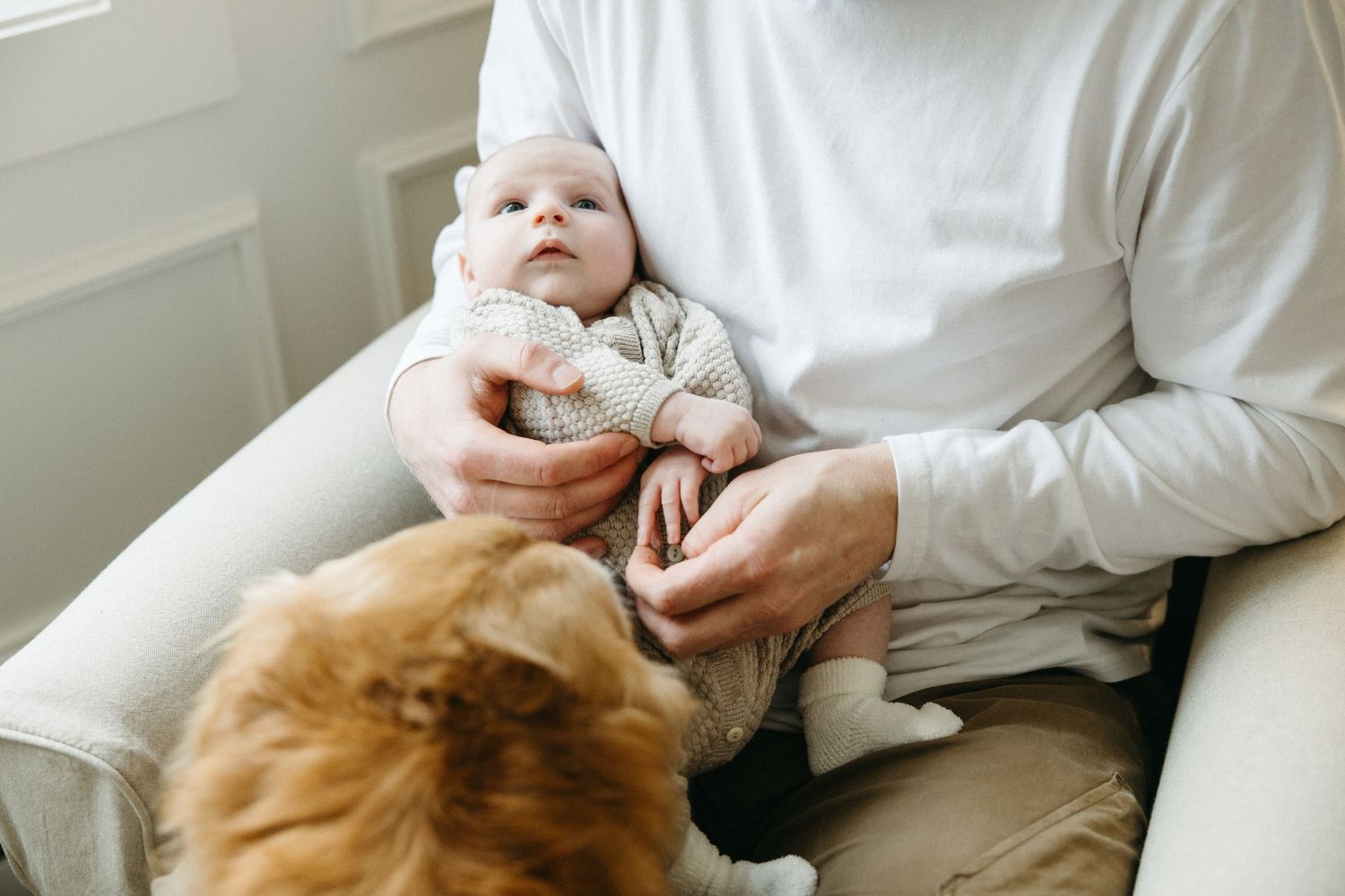 Sweet interaction between baby and caregiver on comfortable couch.