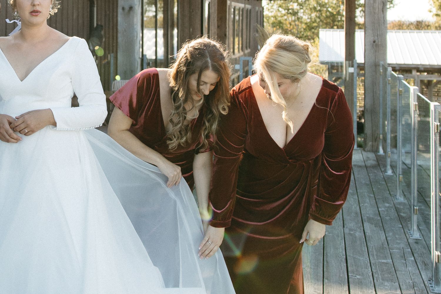 Wedding preparation scene on wooden deck with natural sunlight.