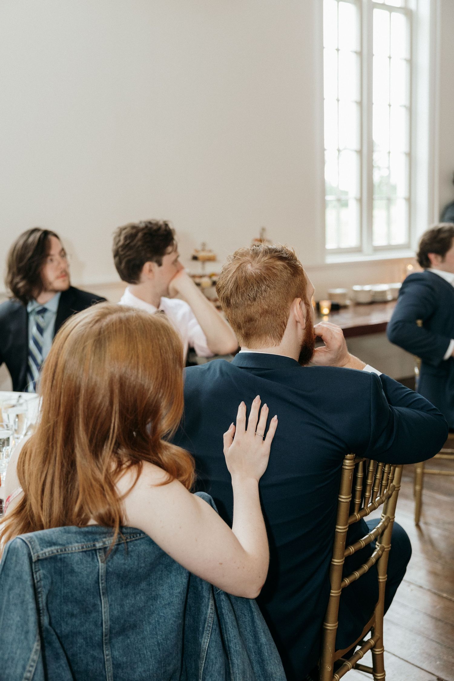Wedding guests reacting emotionally during reception speeches.