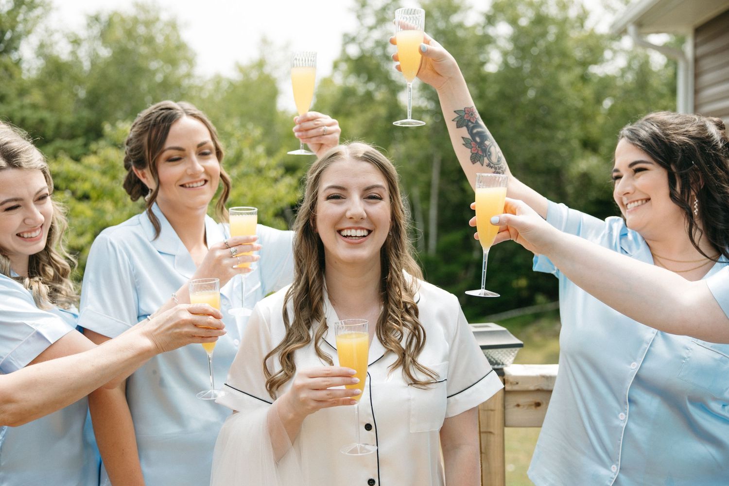A festive outdoor gathering with champagne flutes raised in celebration.